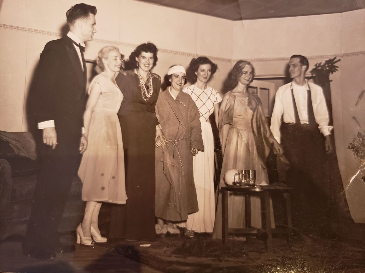 Group of seven people posing indoors, likely a performance or event.