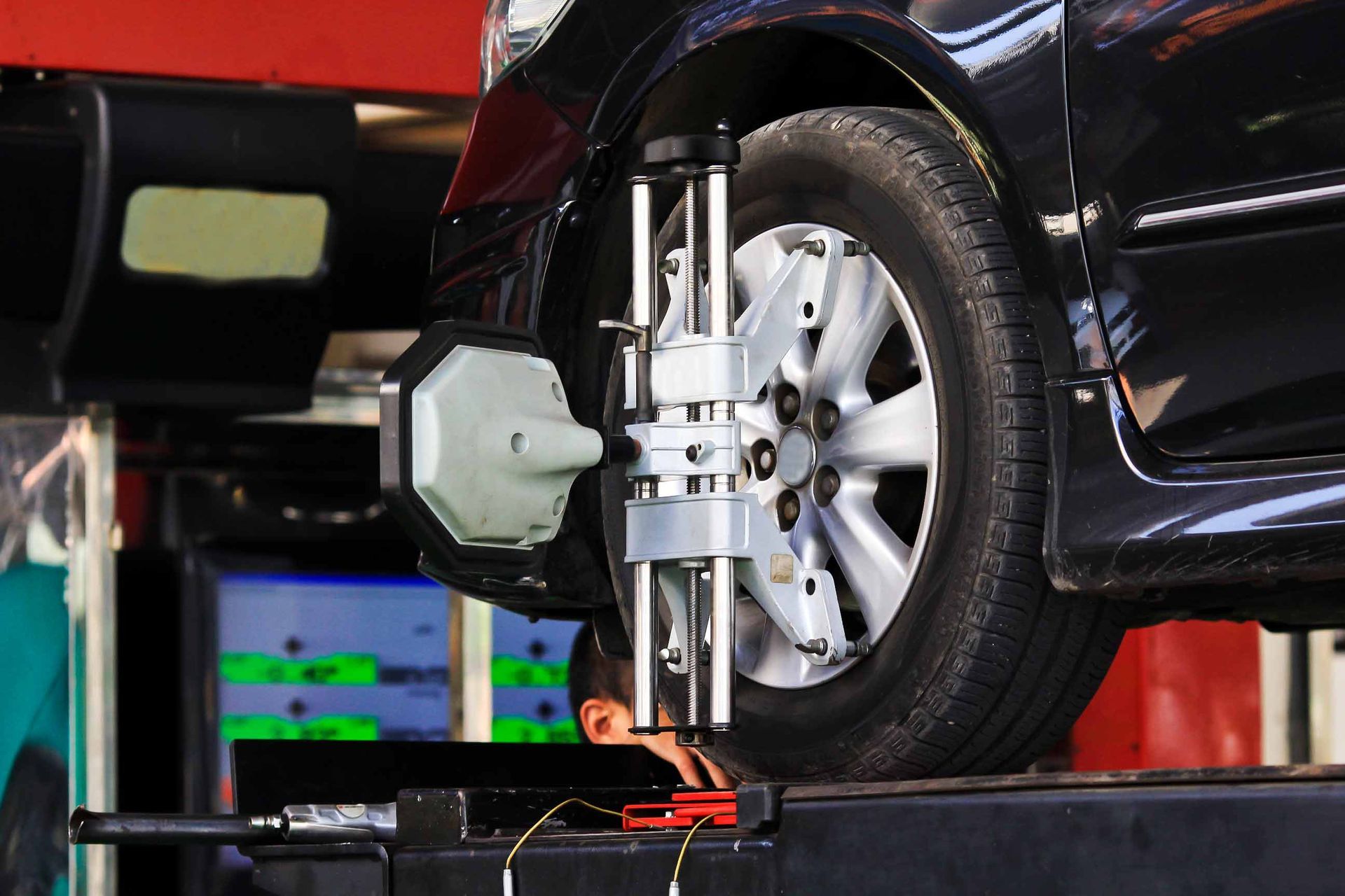 A Car Is Being Adjusted By A Machine In A Garage — Madison, WI — CarZone Auto Experts A Car Is Being Adjusted By A Machine In A Garage — Madison, WI — CarZone Auto Experts
