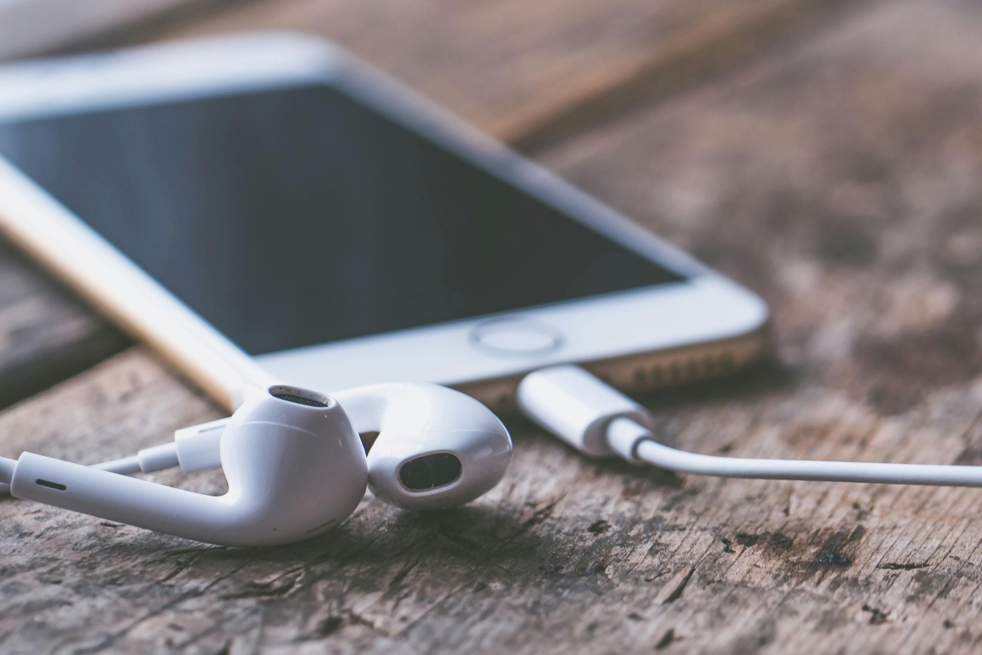 A cell phone with ear buds attached to it