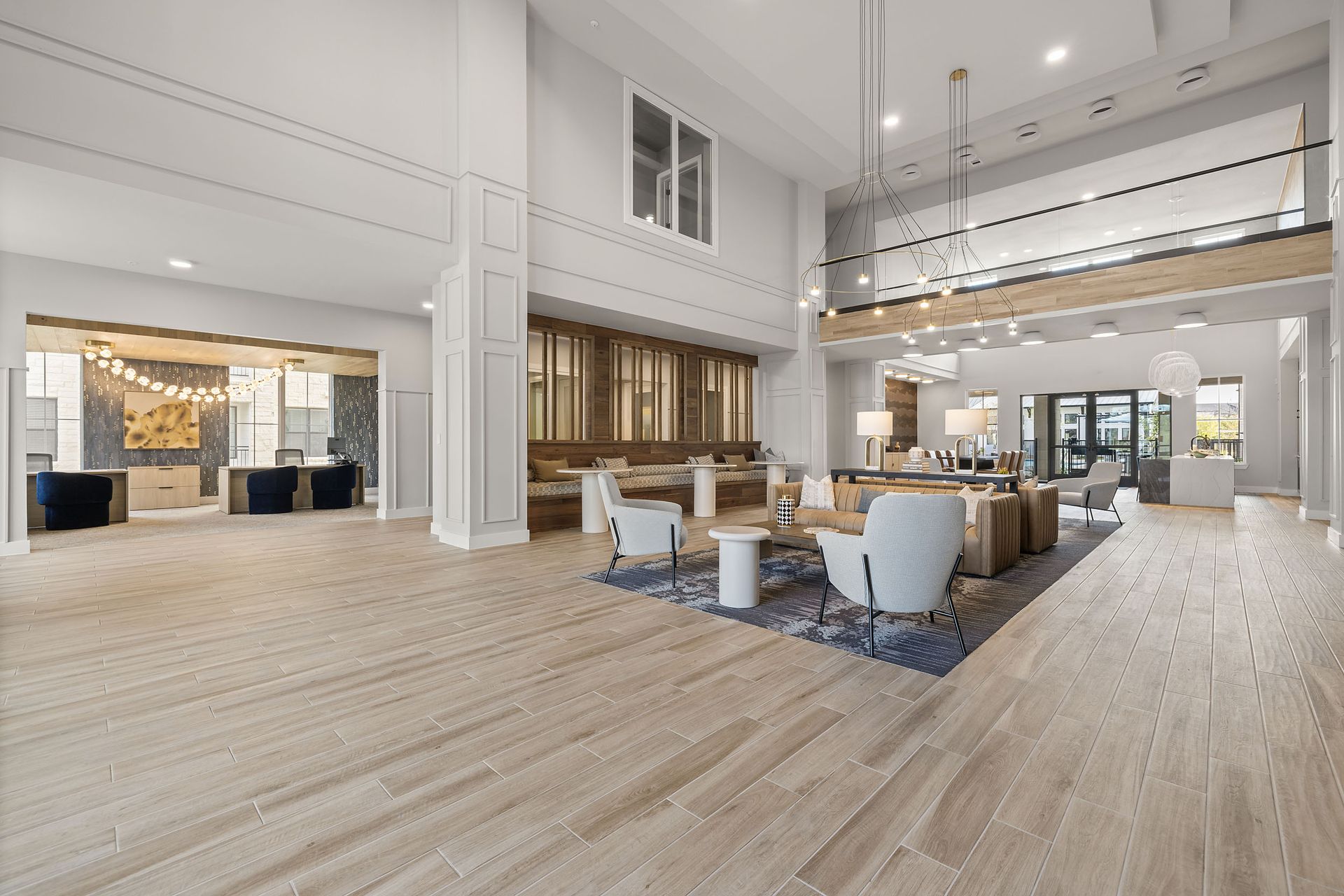 Spacious lobby with light wood floors, seating areas, and modern lighting at The Wyatt, offering apartments for rent in Austin, TX.