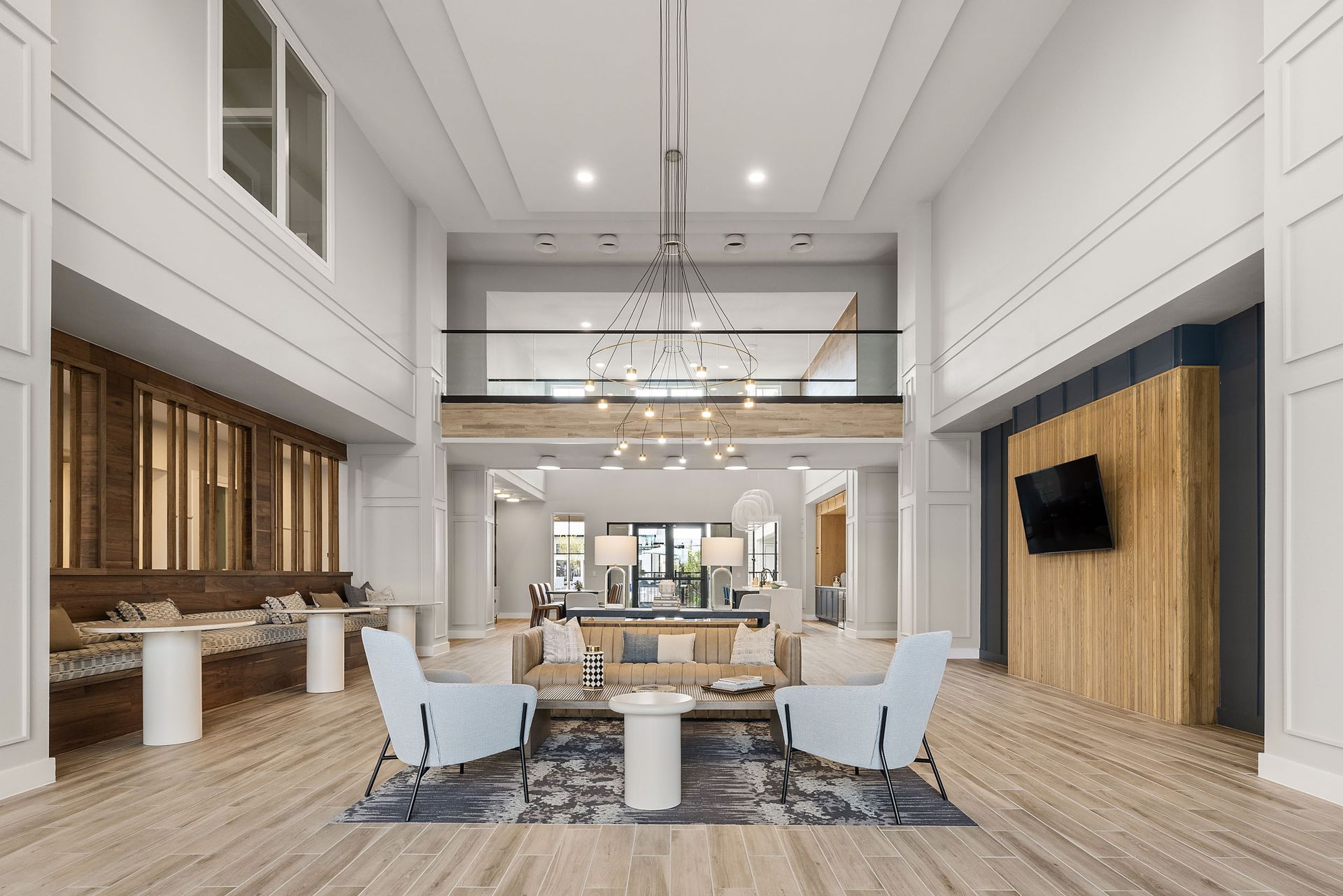 Spacious lobby with high ceilings, light wood floors, and two-story balcony at The Wyatt, offer ingapartments for rent in Austin, TX. Furnished with seating and decorative elements.