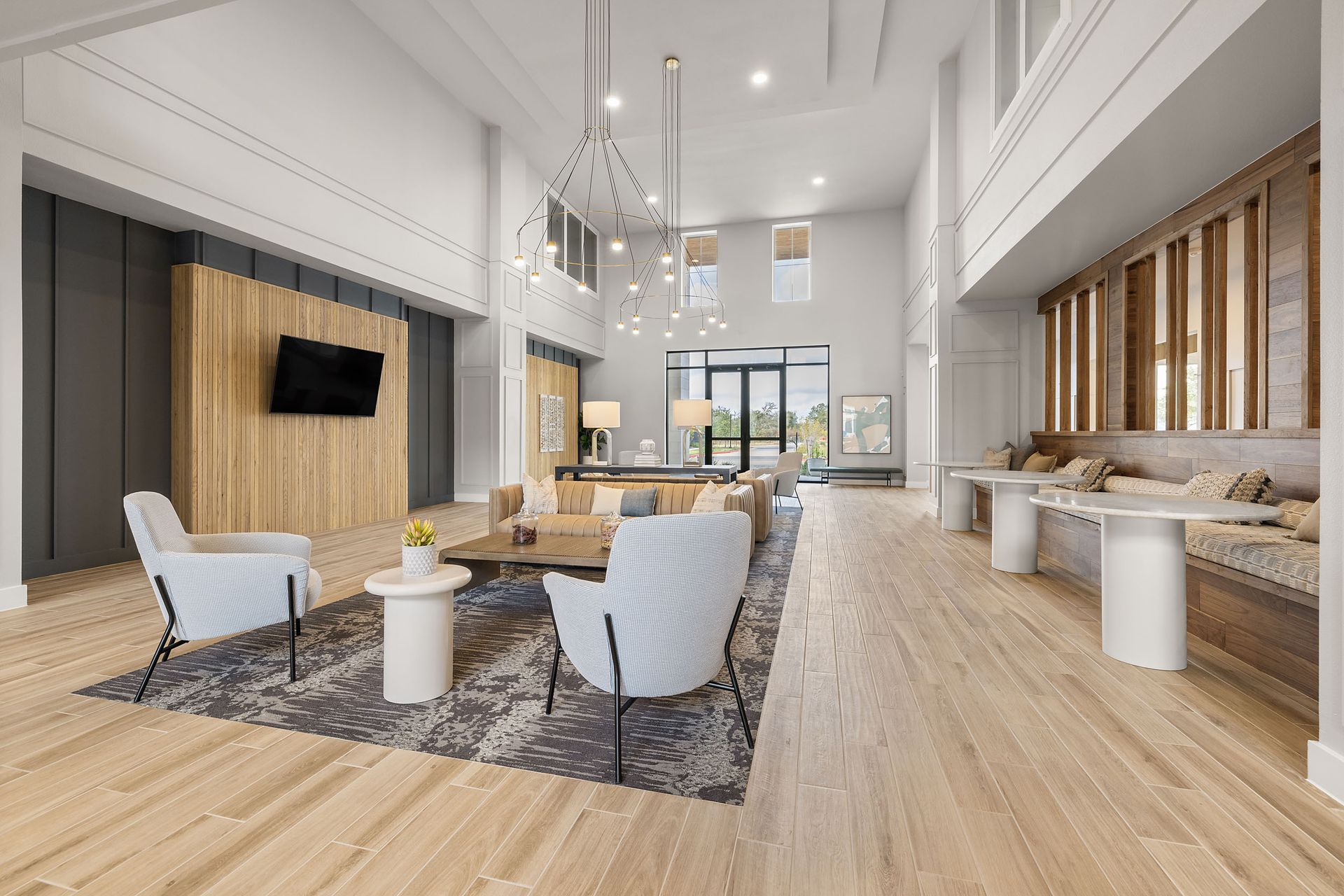 Spacious lobby with wood accents, seating area, TV, and large windows at The Wyatt, offering apartments for rent in Austin, TX.