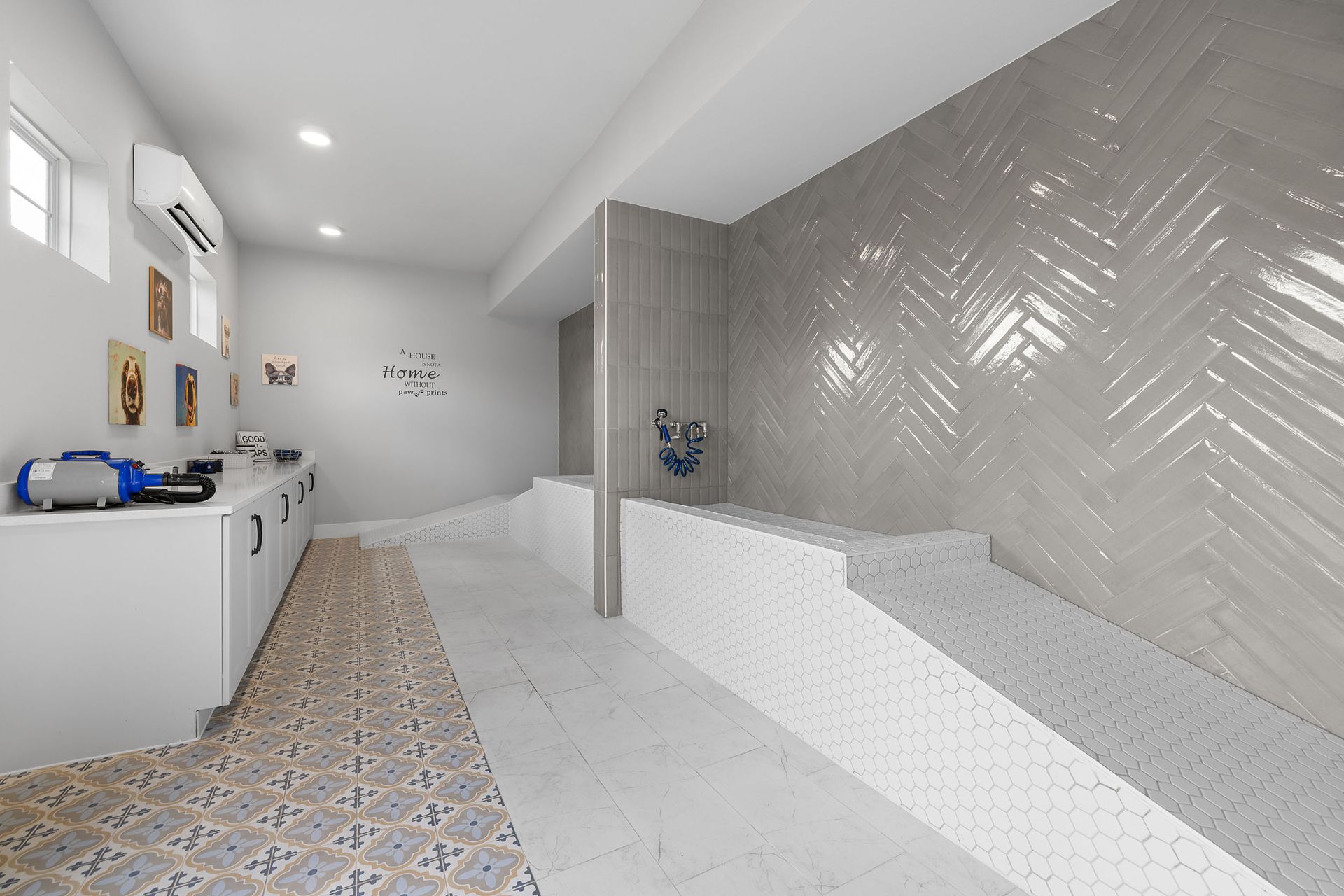 Modern dog spa interior with white and gray tiling, tubs, and grooming stations at The Wyatt, offering Cedar Park luxury apartments.