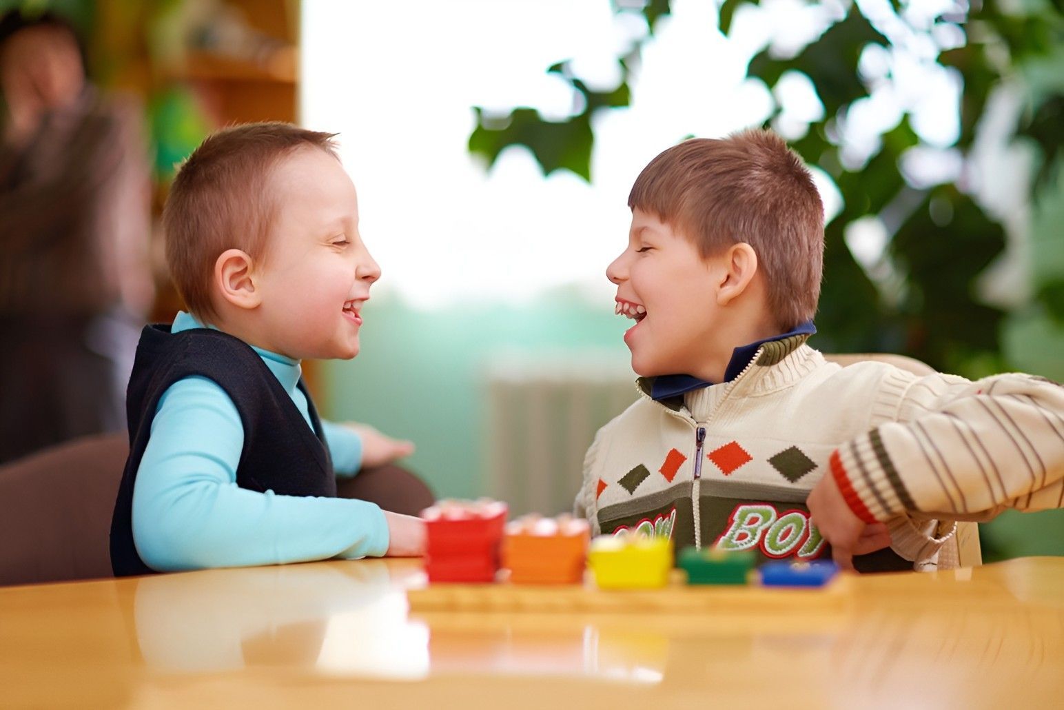 Two Young Boys Are Sitting at a Table Playing With Toys — Birralee Child Care Centre Assn Inc In Mackay, QLD