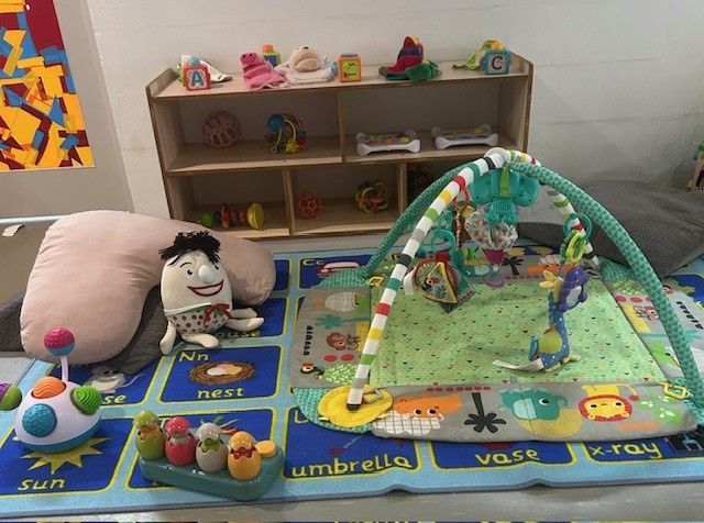 A Woman and Two Children Are Sitting at a Table Painting โ Birralee Child Care Centre Assn Inc In Mackay, QLD