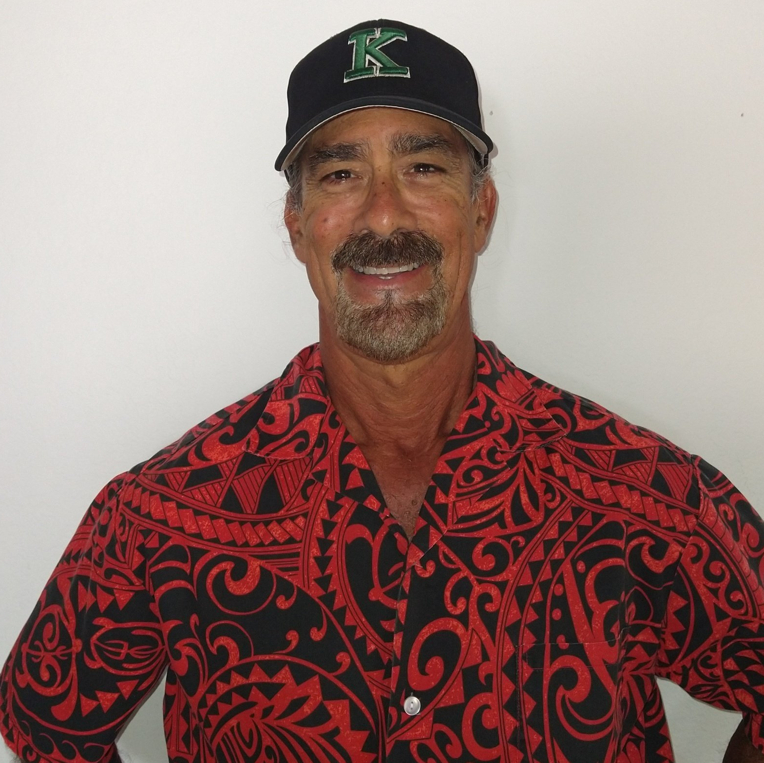 A man wearing a hat with the letter k on it