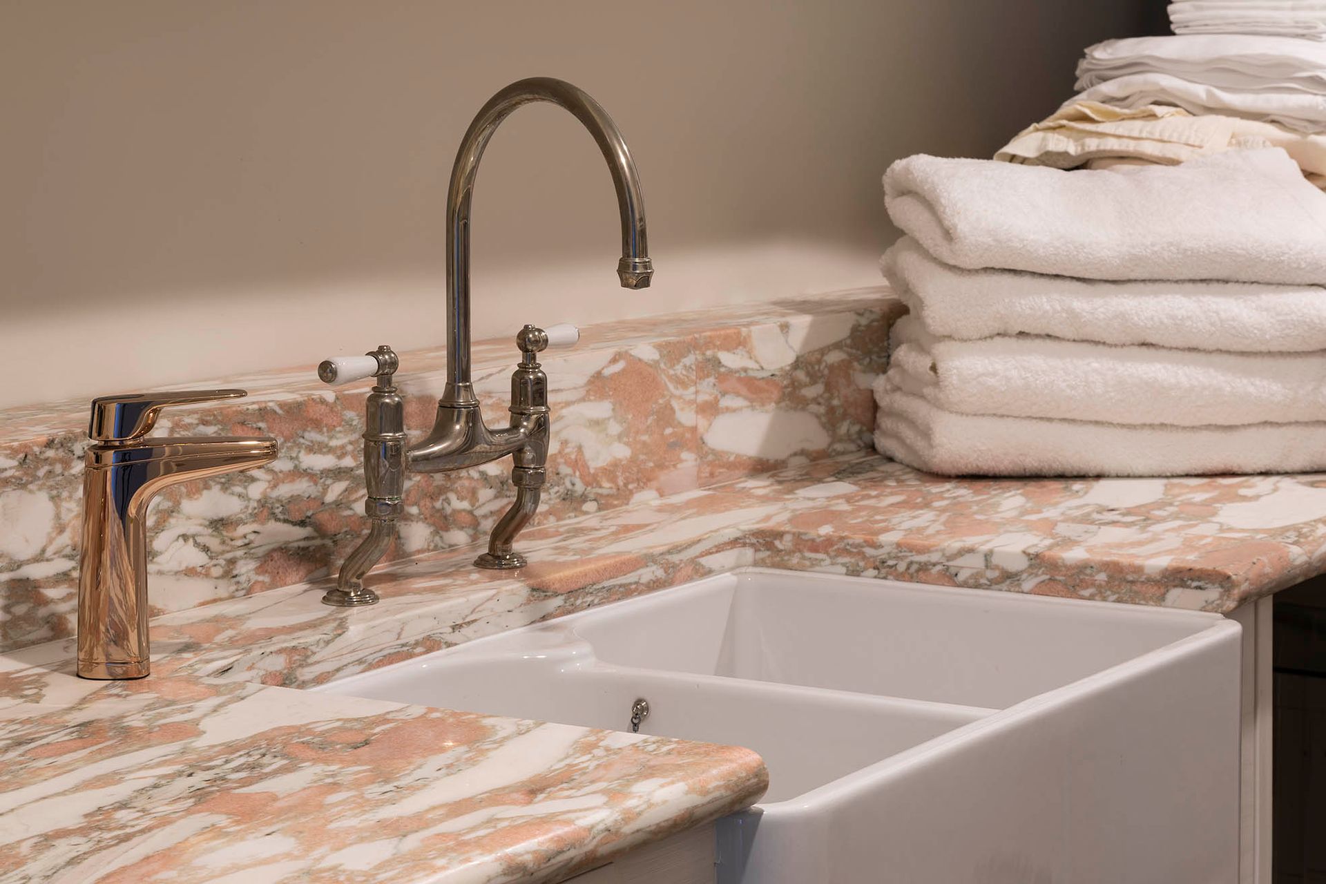 Kitchen sink with marble countertop, chrome faucet, and stacked white towels on the right — Shona O'Brien Interior Design in Bowral, NSW