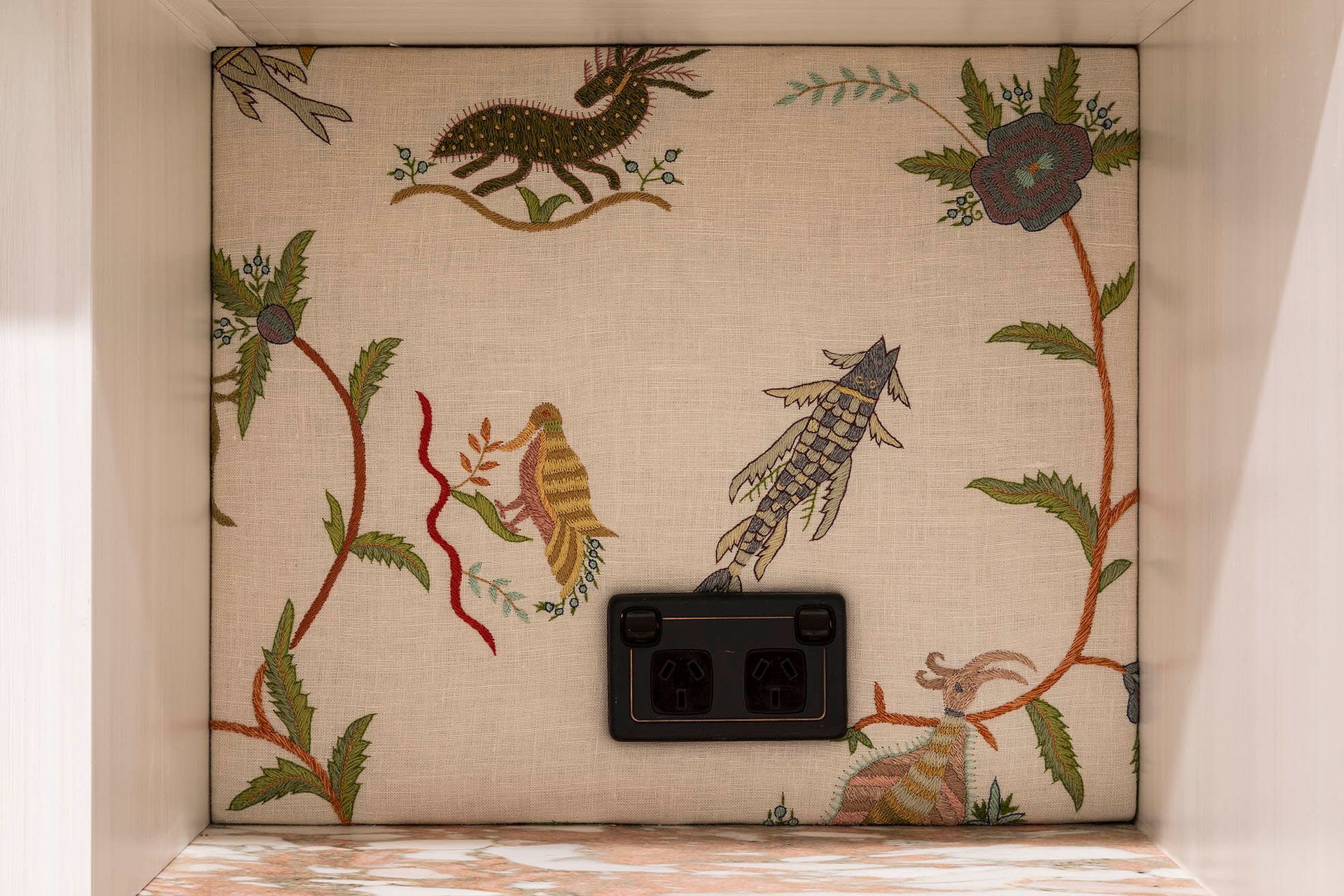 Decorative floral tile wall with bird illustrations and a black electrical outlet panel — Shona O'Brien Interior Design in Bowral, NSW
