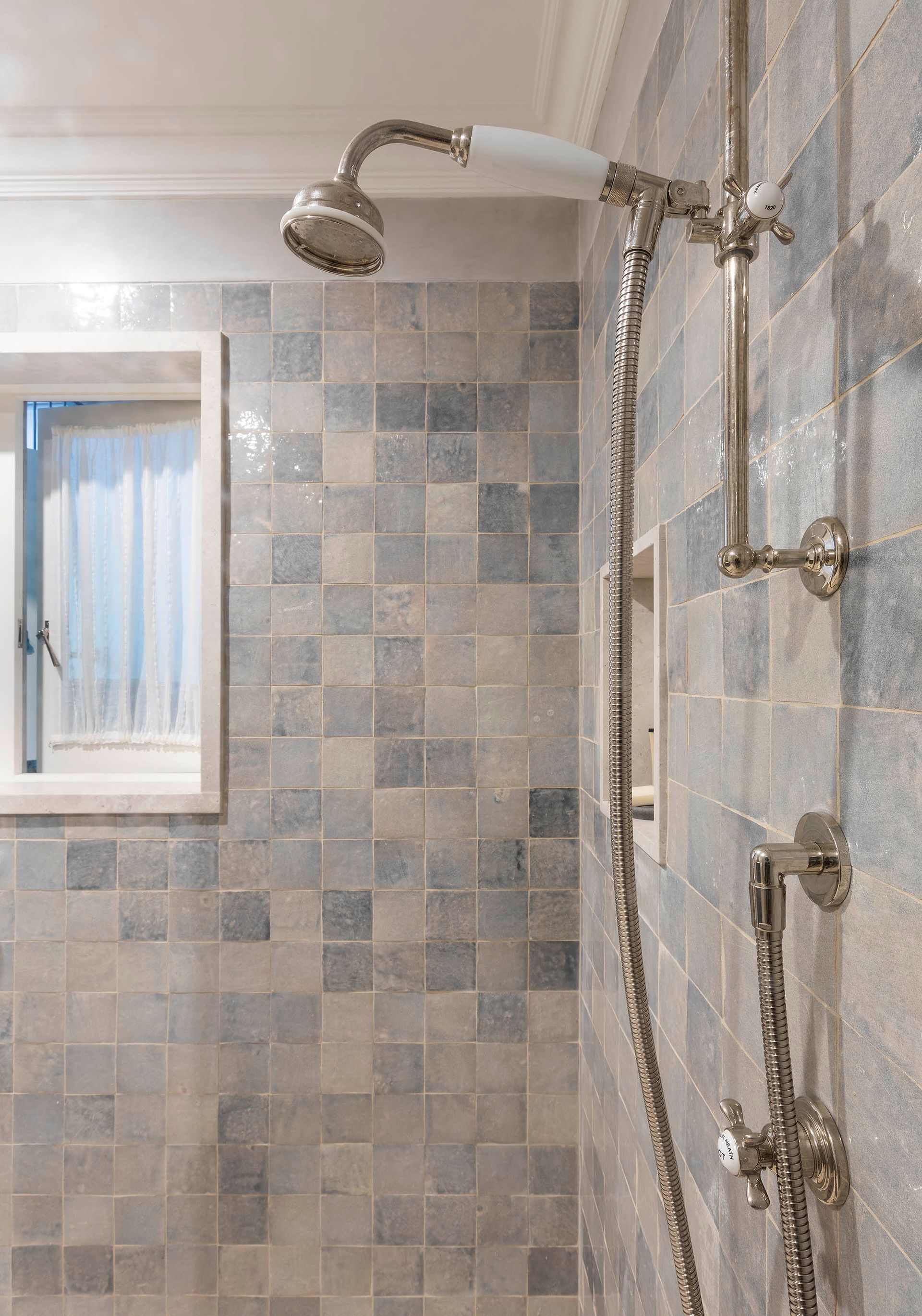 Bathroom shower with tiled walls, handheld showerhead, and a small window — Shona O'Brien Interior Design in Bowral, NSW