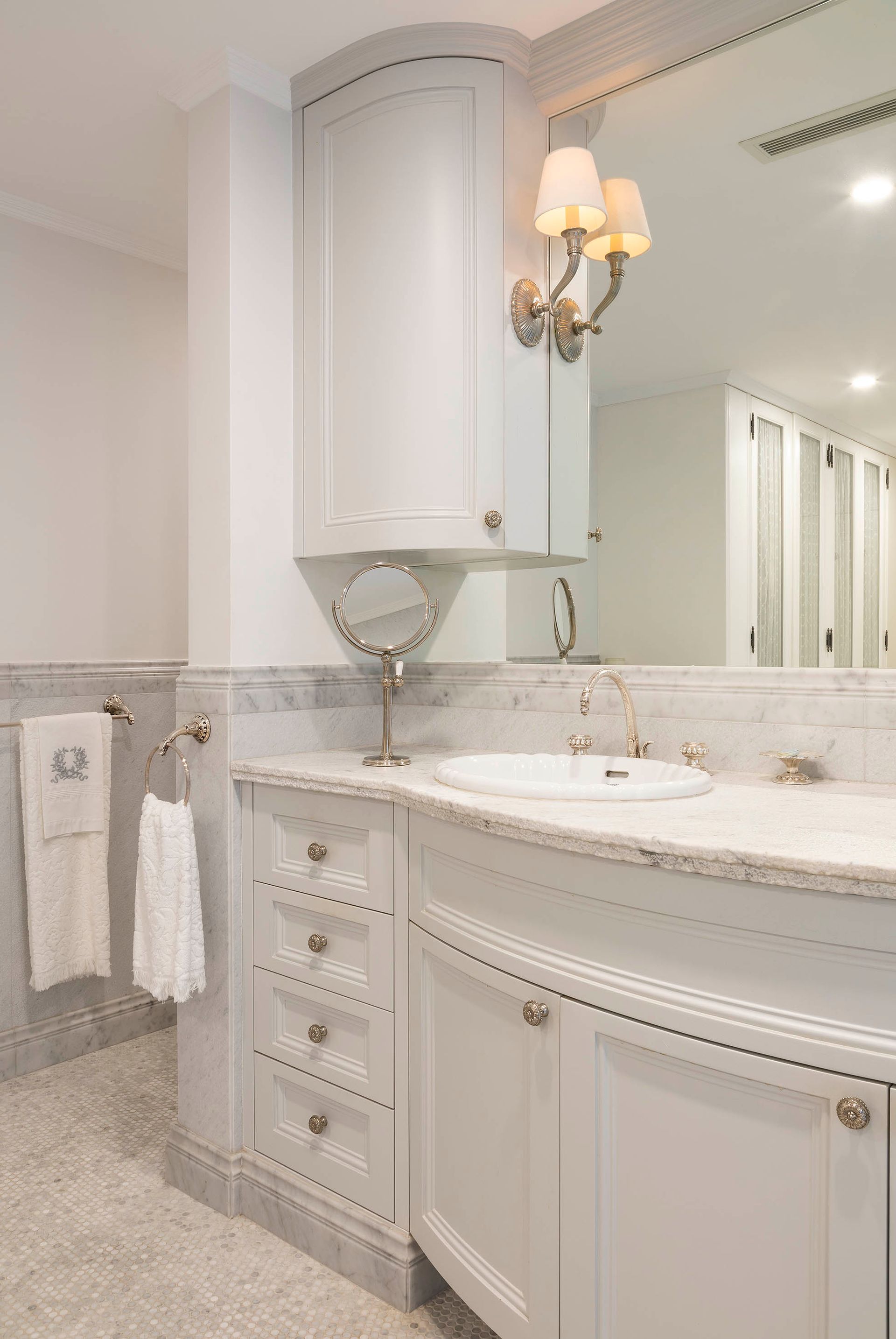 Bright marble bathroom vanity with mirrored cabinets, white cabinetry, and wall sconces — Shona O'Brien Interior Design in Bowral, NSW