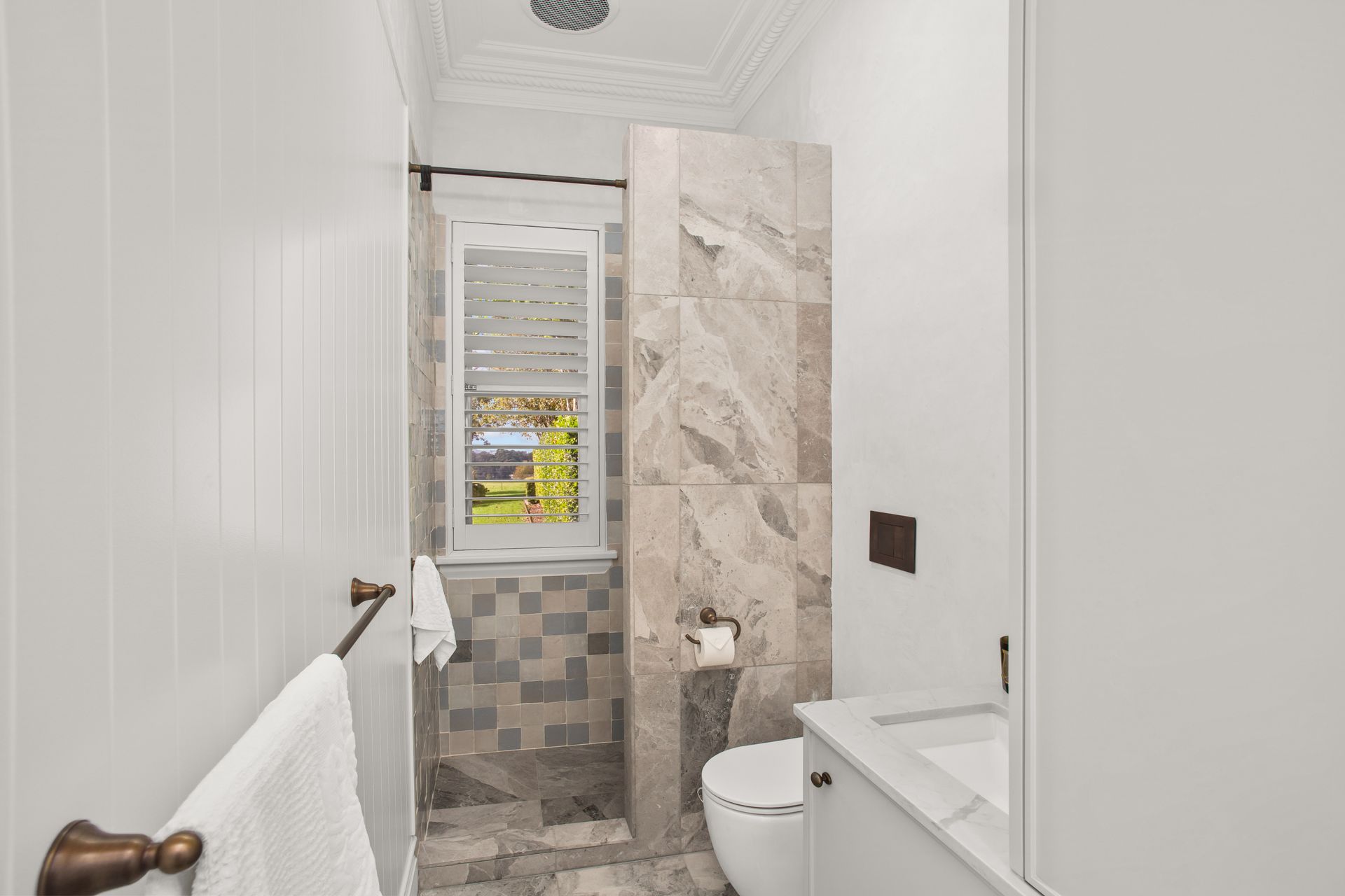 Narrow White Bathroom With Tiled Shower, Toilet, Sink, And Towel Rack Near A Window — Shona Design In Mittagong, NSW