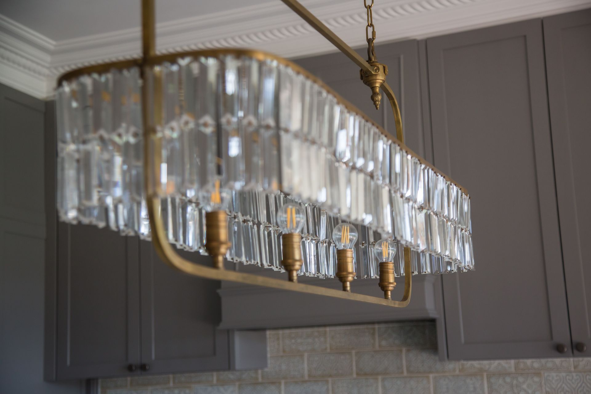 Modern Rectangular Crystal Chandelier Hanging In A Gray Kitchen — Shona Design In Mittagong, NSW