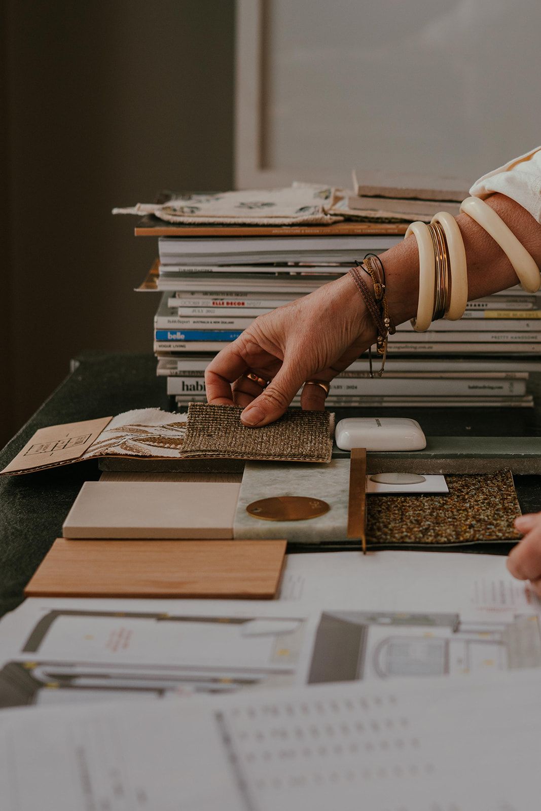 Hand Selecting Flooring Samples From a Stack of Tiles and Wood Swatches — Shona O'Brien Interior Design in Bowral, NSW