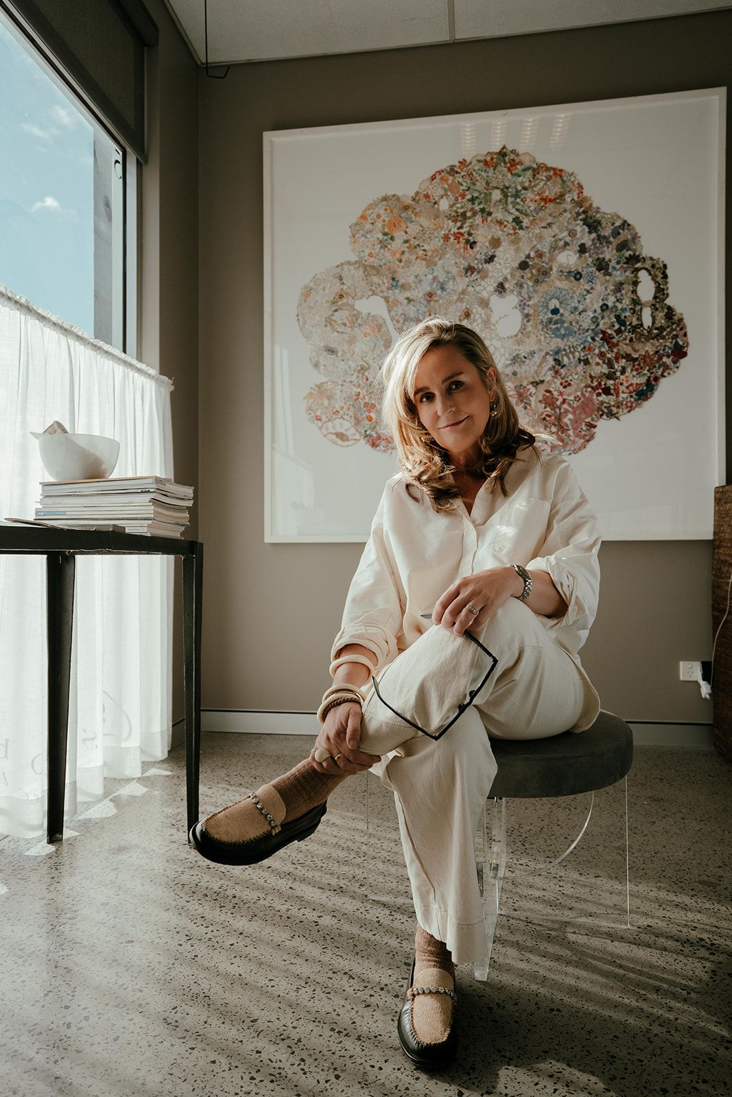 Woman Seated by a Window in a Modern Room, Wearing Cream Clothes — Shona O'Brien Interior Design in Bowral, NSW