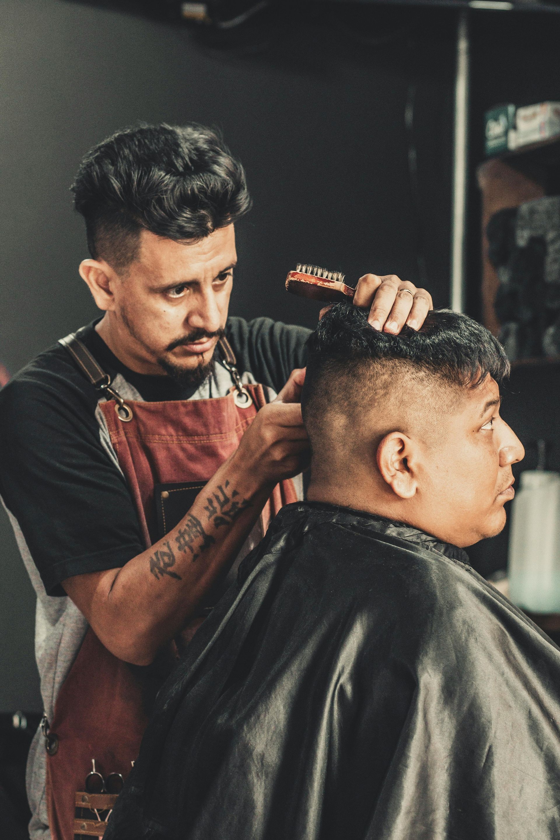 A man is getting his hair cut by a barber in a barber shop.