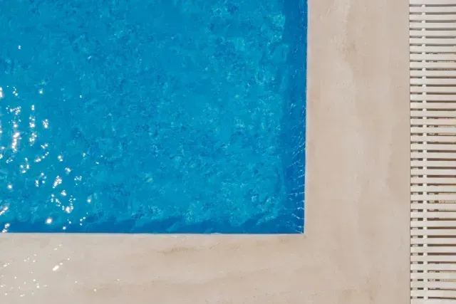 Blue textured square artwork on a beige wall beside a white slatted panel