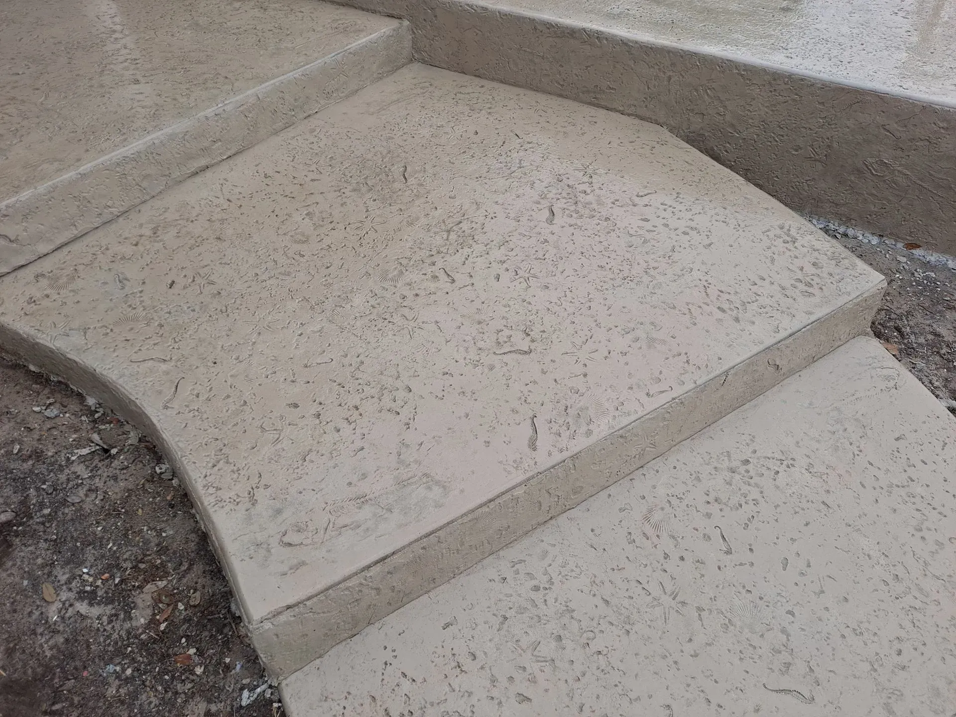 Curved concrete walkway with a step and gravel borders
