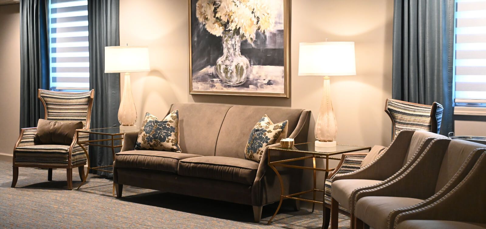 A living room with a couch and chairs and a painting on the wall.