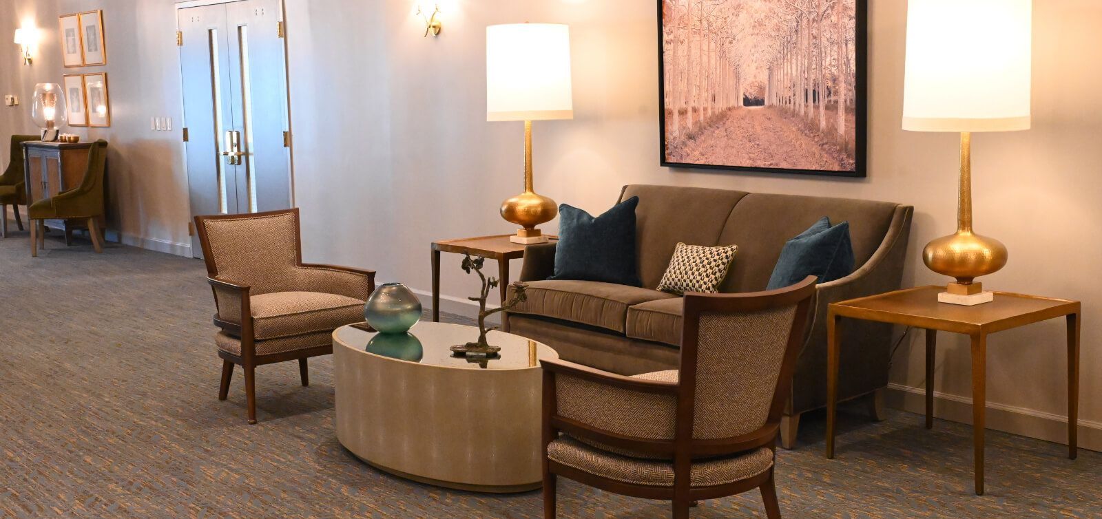 A living room with a couch , chairs , tables and lamps.