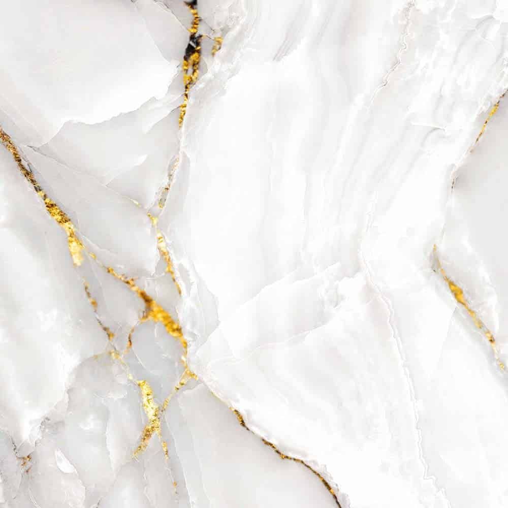 A close up of a white marble texture with gold veins.