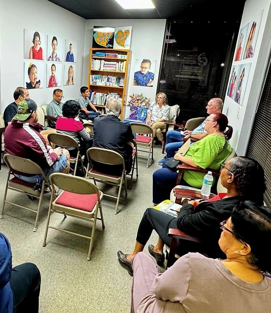 A group of people are sitting in chairs in a room.