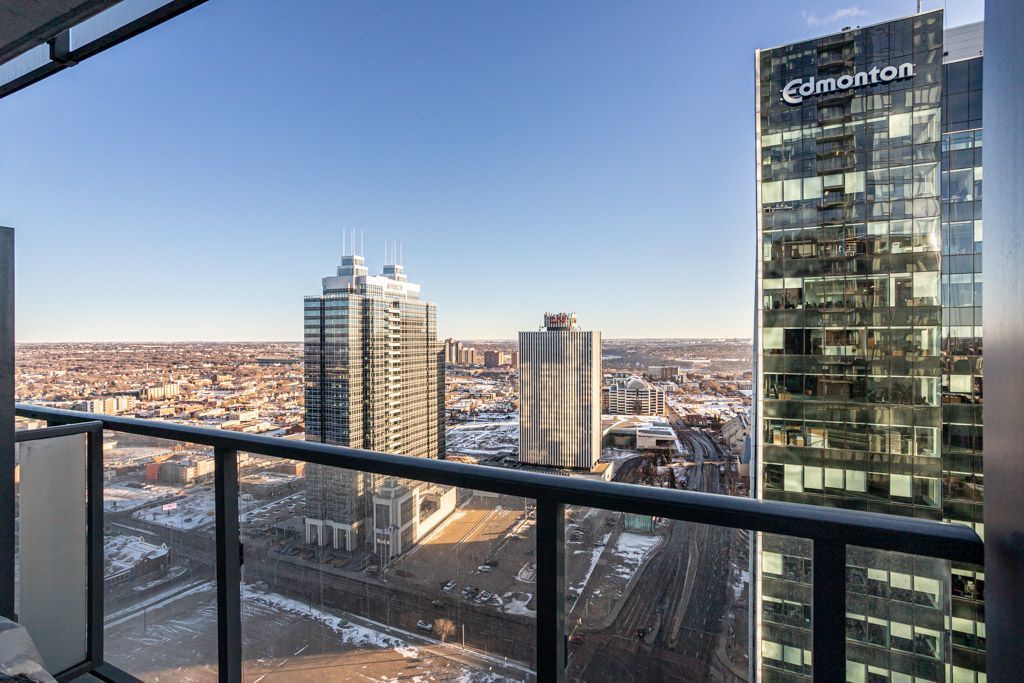 Cityscape view from a balcony with several tall buildings, including one that reads 
