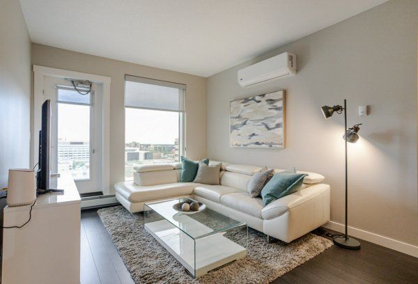 Modern living room with white sectional, large window, and artwork.
