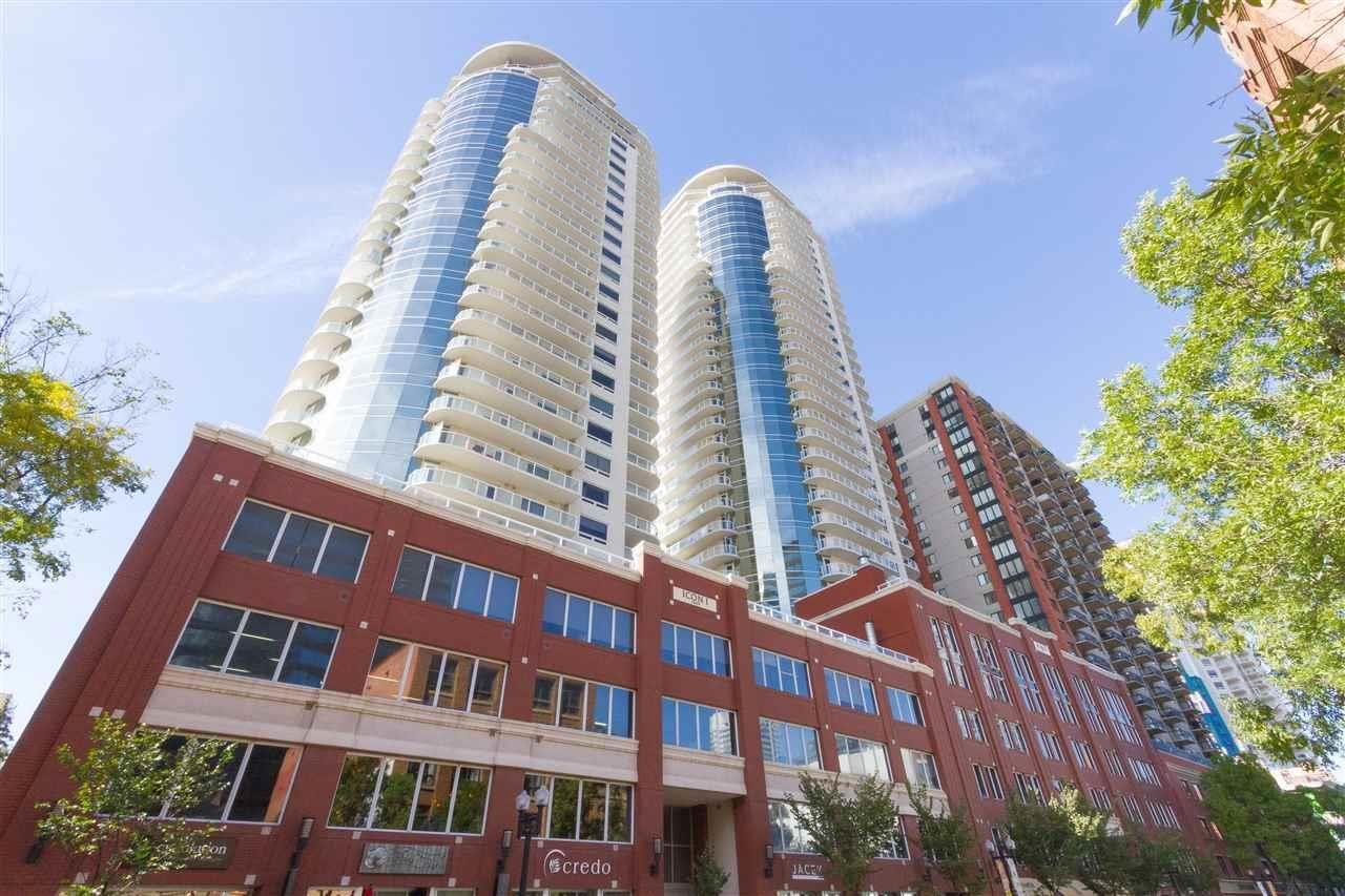 Twin white towers  with red brick brick podium in the daytime busy street in front of it
