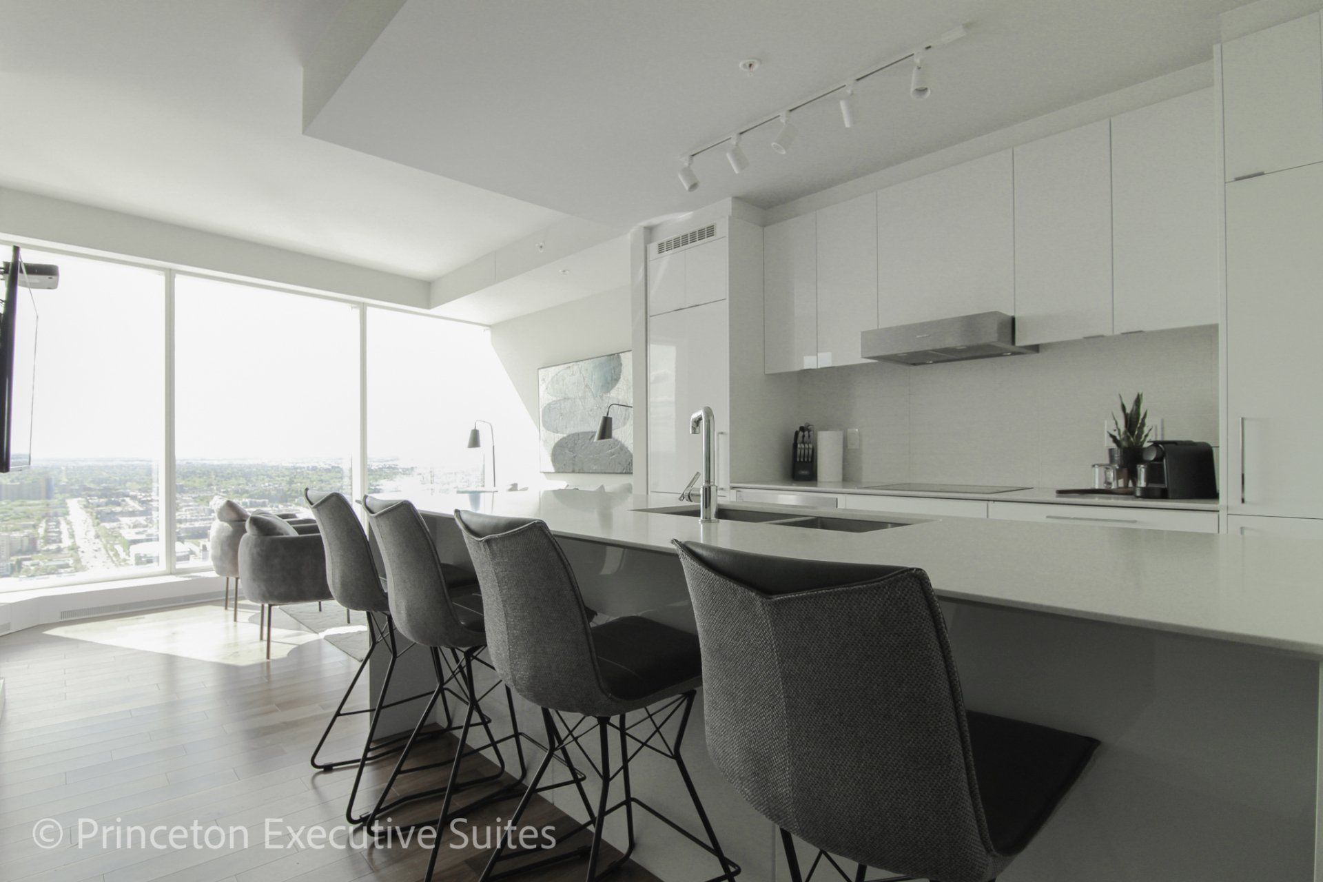 4 grey high back barstools white cabinets in the back ground in this spacious edmonton furnished apartment in Edmonton