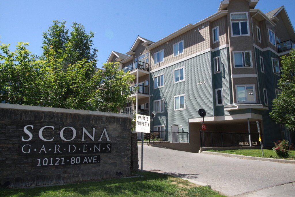 Street Entrance way blue 4 story building with sign that says Scona Gardens