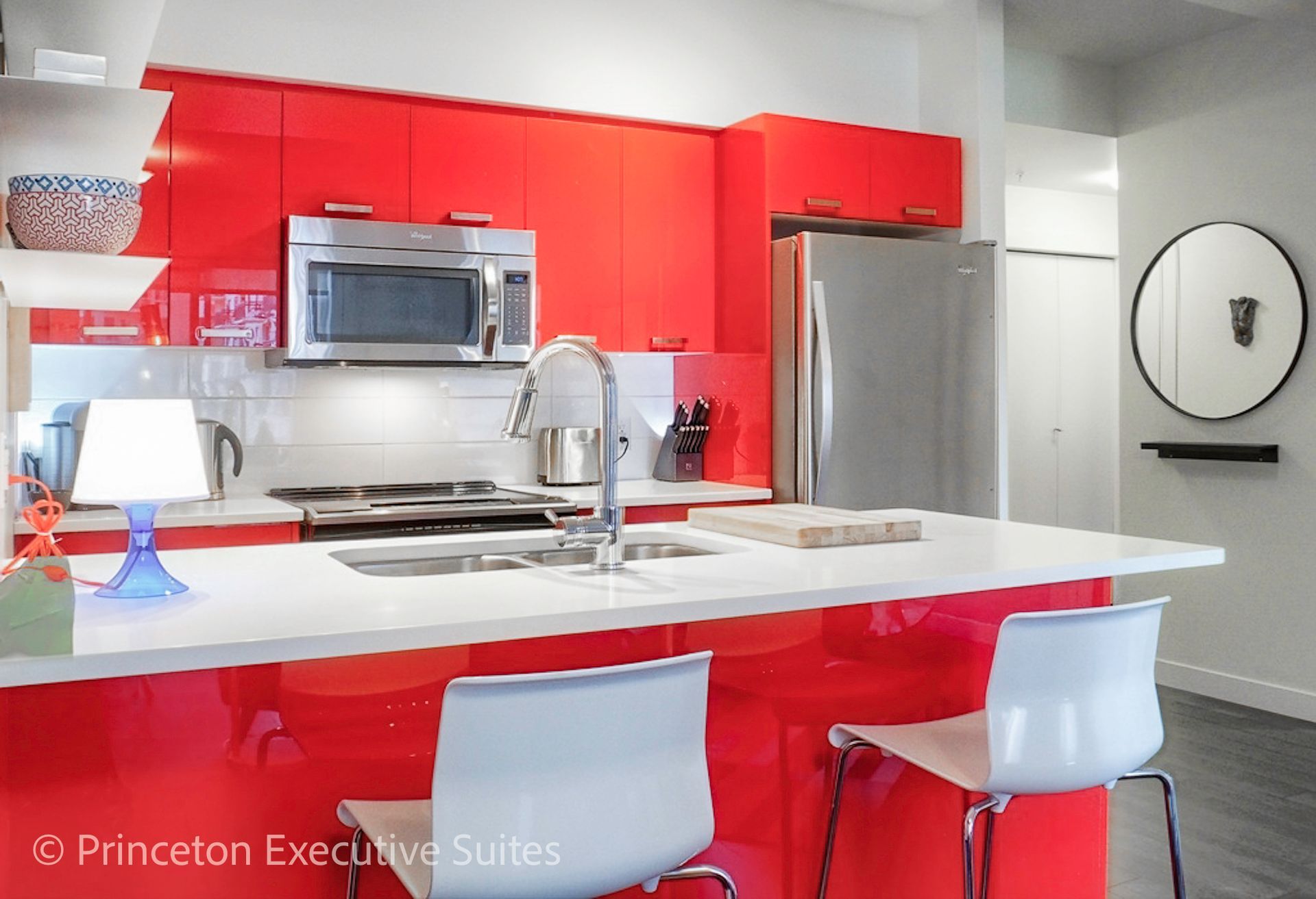 Red modern kitchen with island, stainless steel appliances, and white accents.