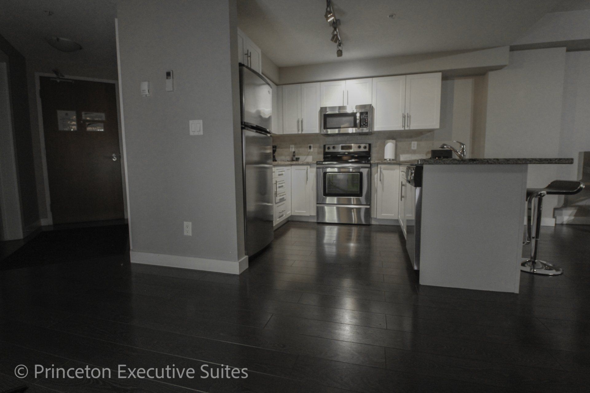 Dark hardwood flooring grey couch and espresso hardwood in his this living room of edmonton corporate suite