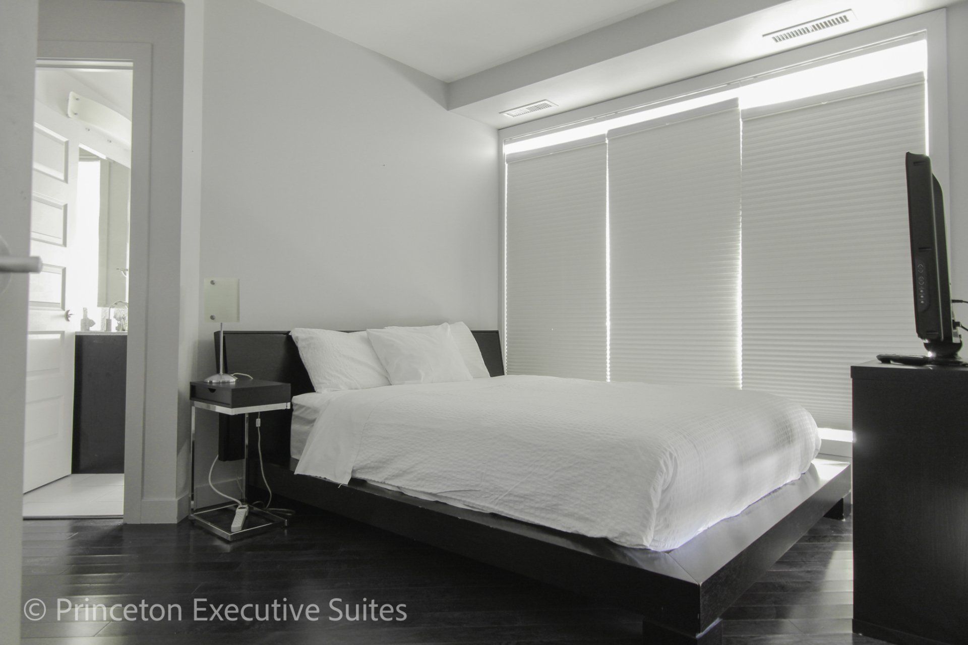 Bedroom with queen bed and white linens
