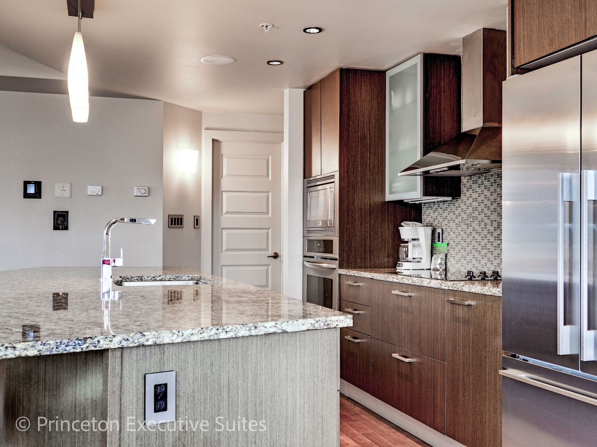 Modern kitchen with wood cabinets, granite countertops, and stainless steel appliances.
