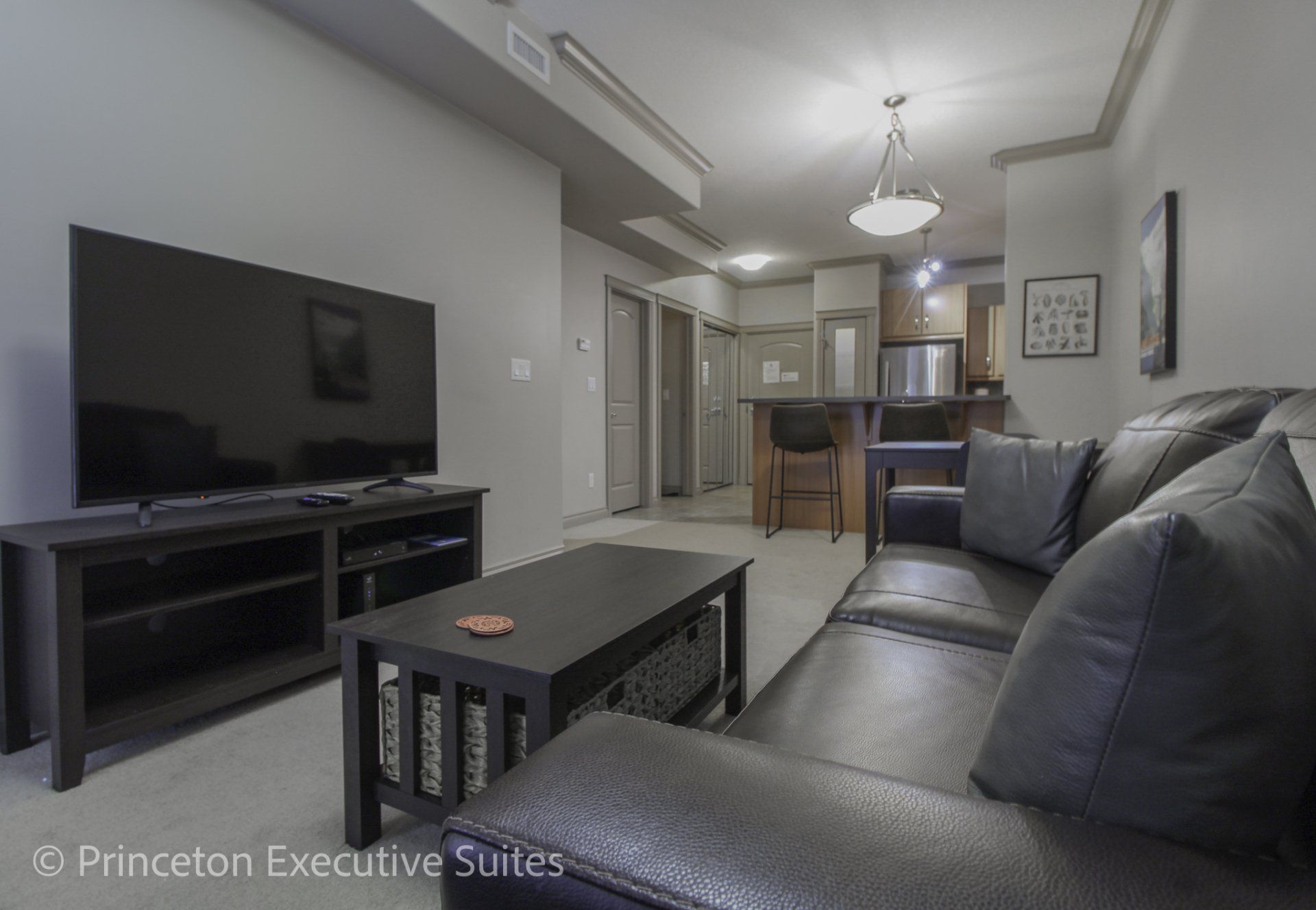 Living room brown couch Tv and dingin in the background Edmonton furnished apartment