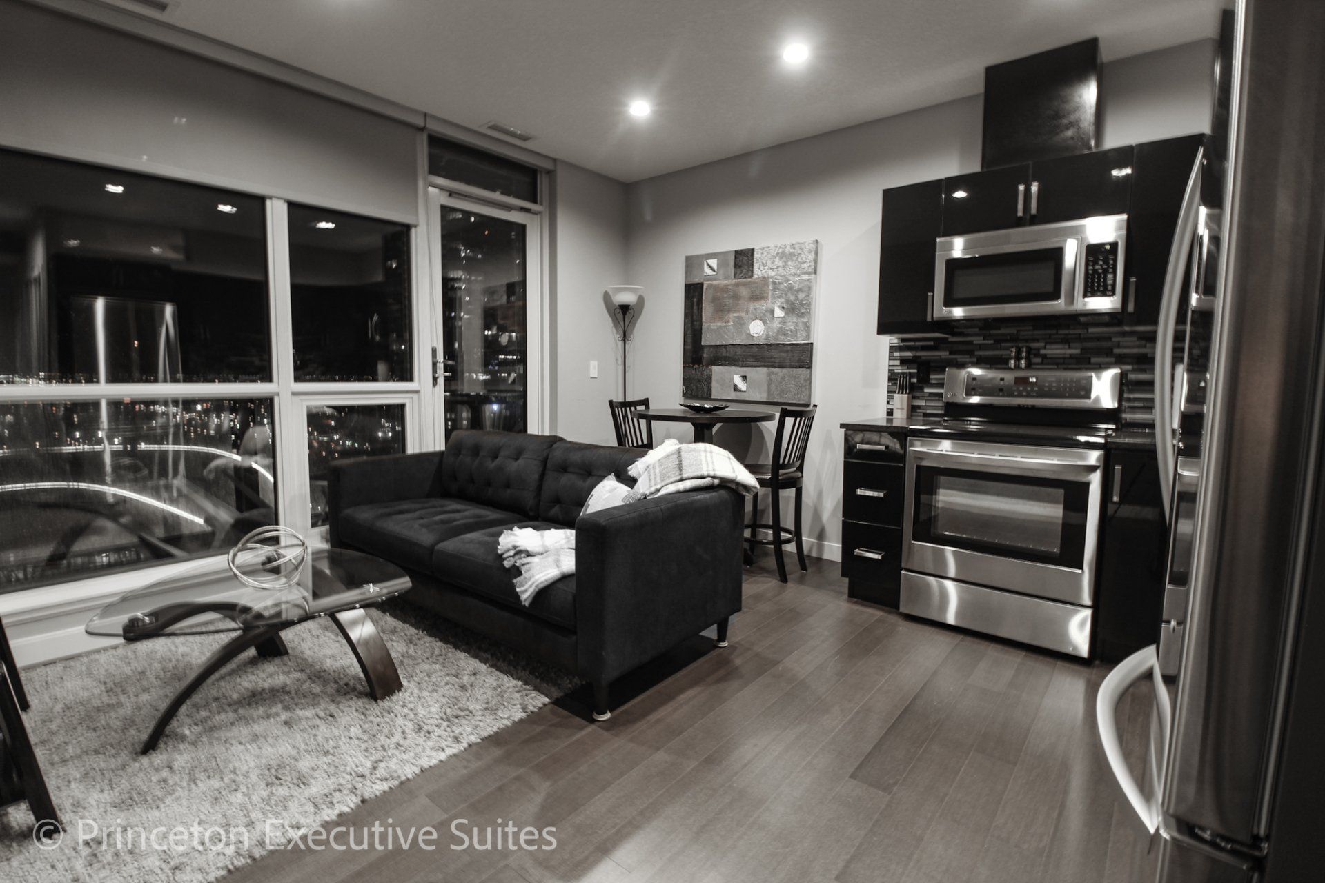Living area with charcoal couch dining room table and coffee table