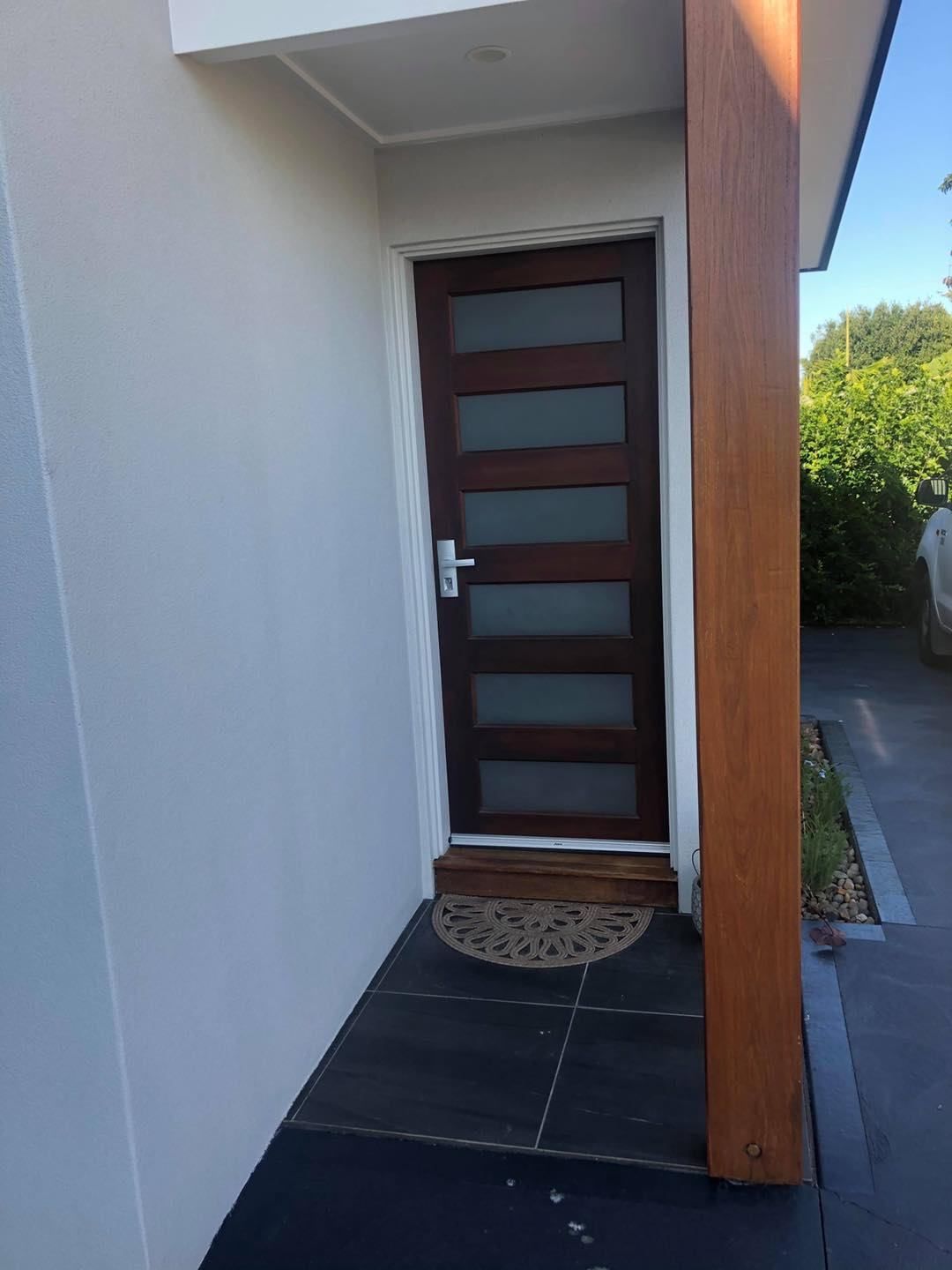 The Front Door Of A House With A Door Mat On The Ground — Central Coast Flyscreen Service In Warnervale, NSW