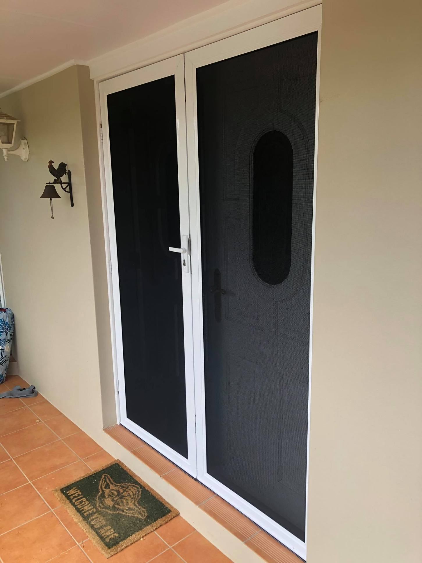 There Is A Door With A Screen On It And A Door Mat On The Floor — Central Coast Flyscreen Service In West Gosford, NSW