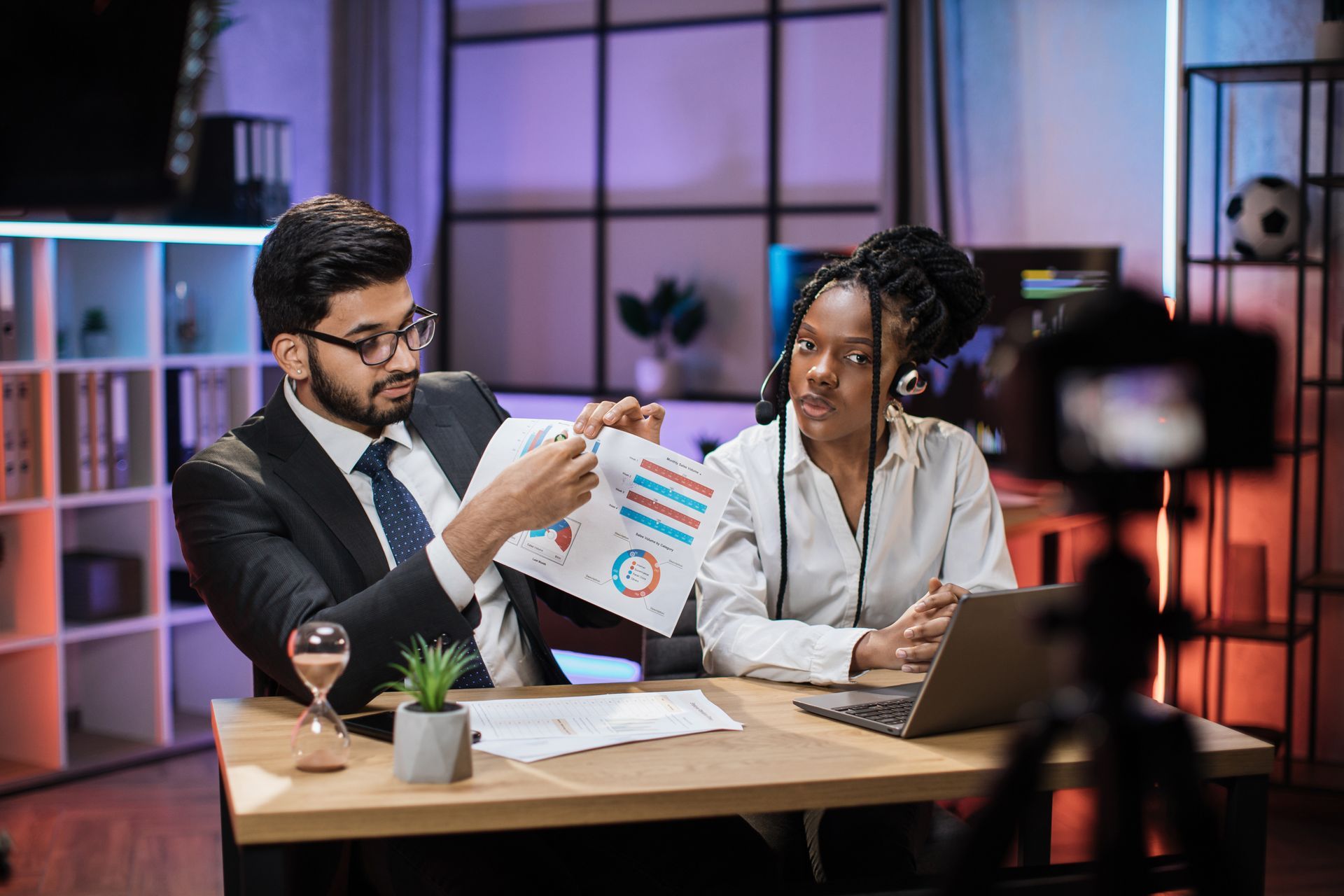 A man and a woman are sitting at a table looking at a piece of paper.