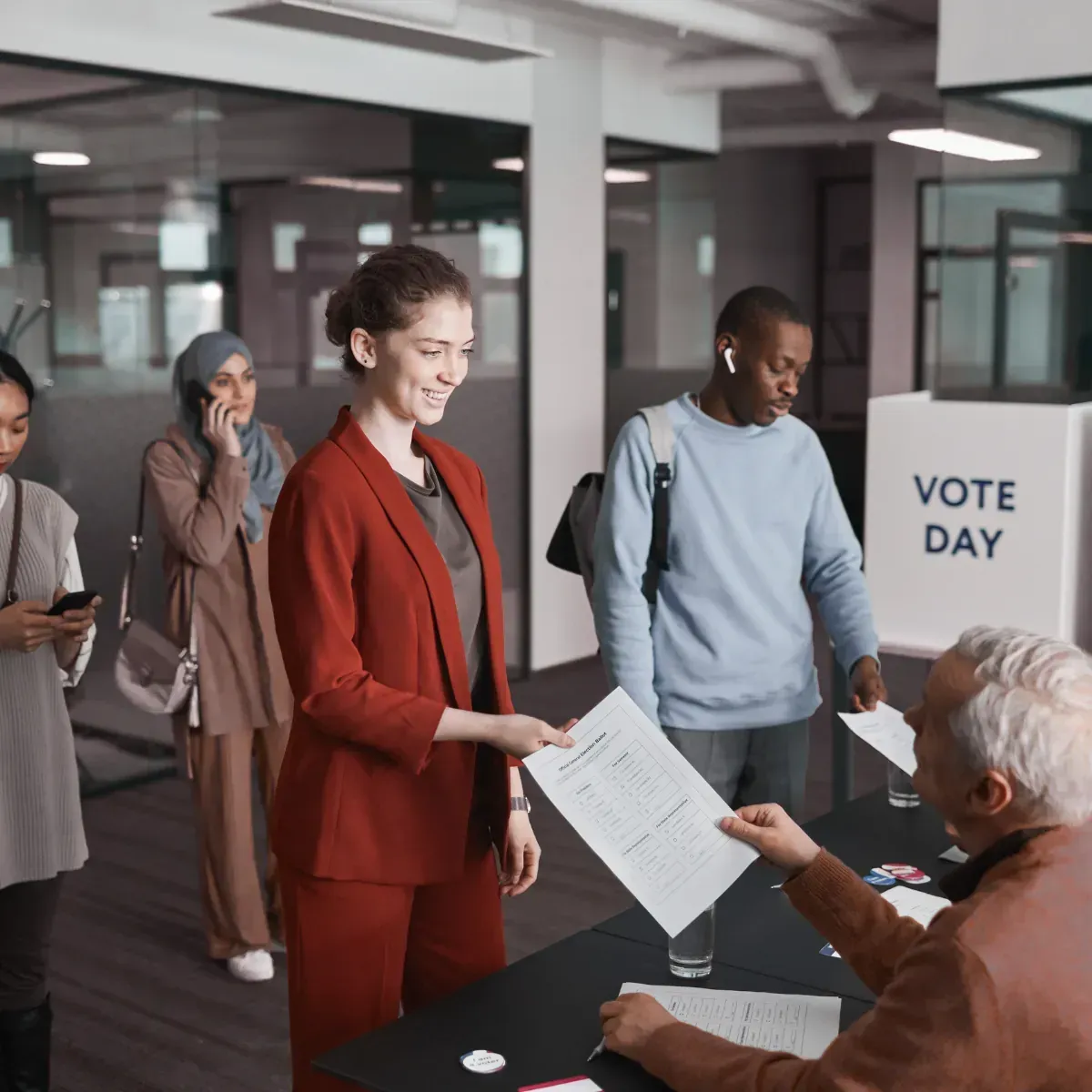 A group of people are standing around a table at a voting booth.