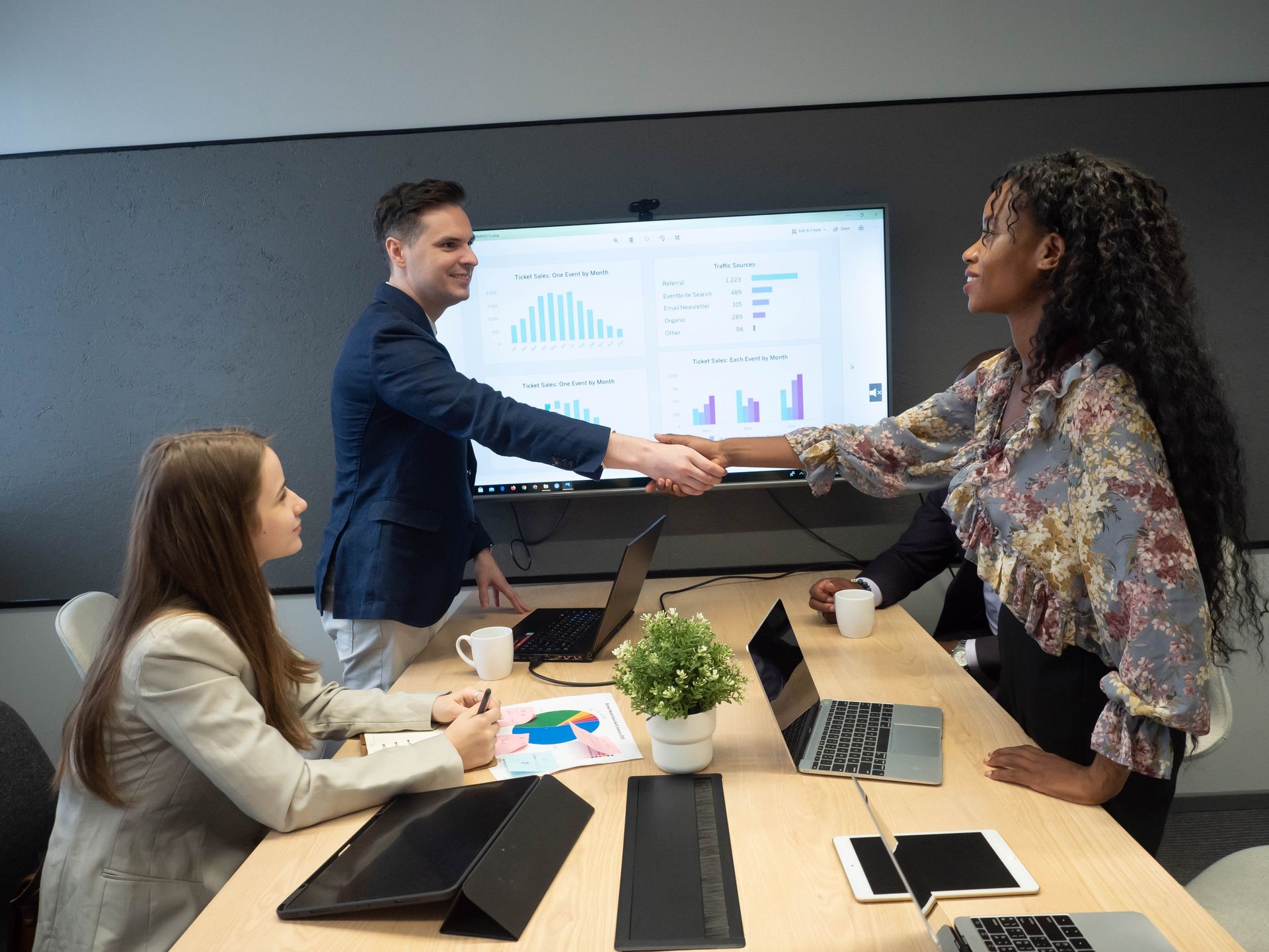 A group of people are shaking hands in a conference room.