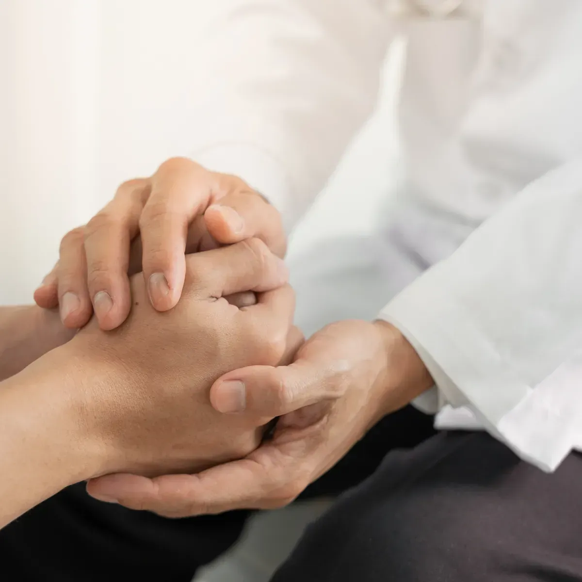 A close up of a person holding another person 's hand.