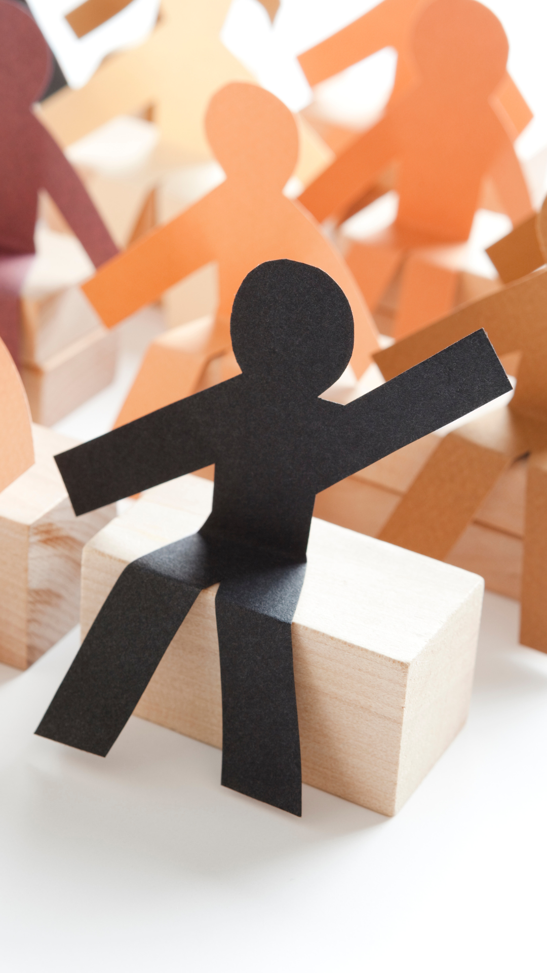 A paper cut out of a man is sitting on a wooden box