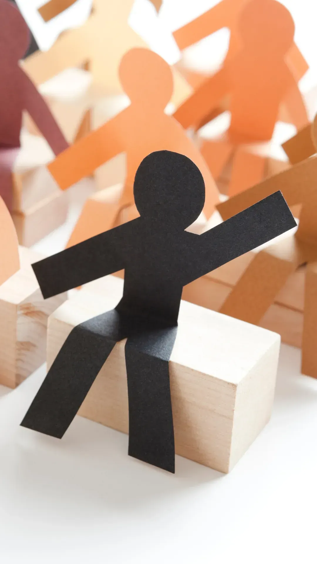 A paper cut out of a man is sitting on a wooden box