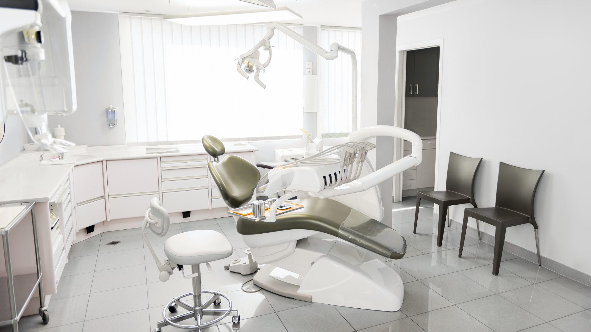 A dental office with a dental chair and chairs.