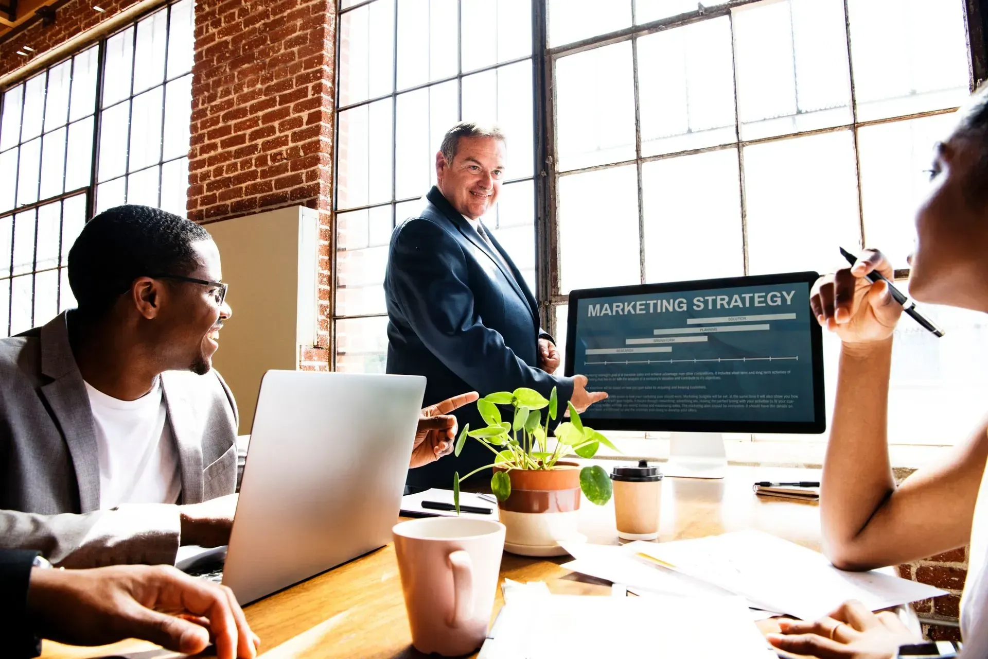 A group of people are sitting at a table in front of a computer.