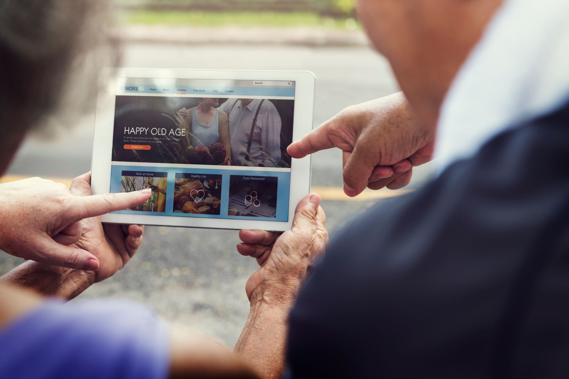 A man and a woman are looking at a tablet together.