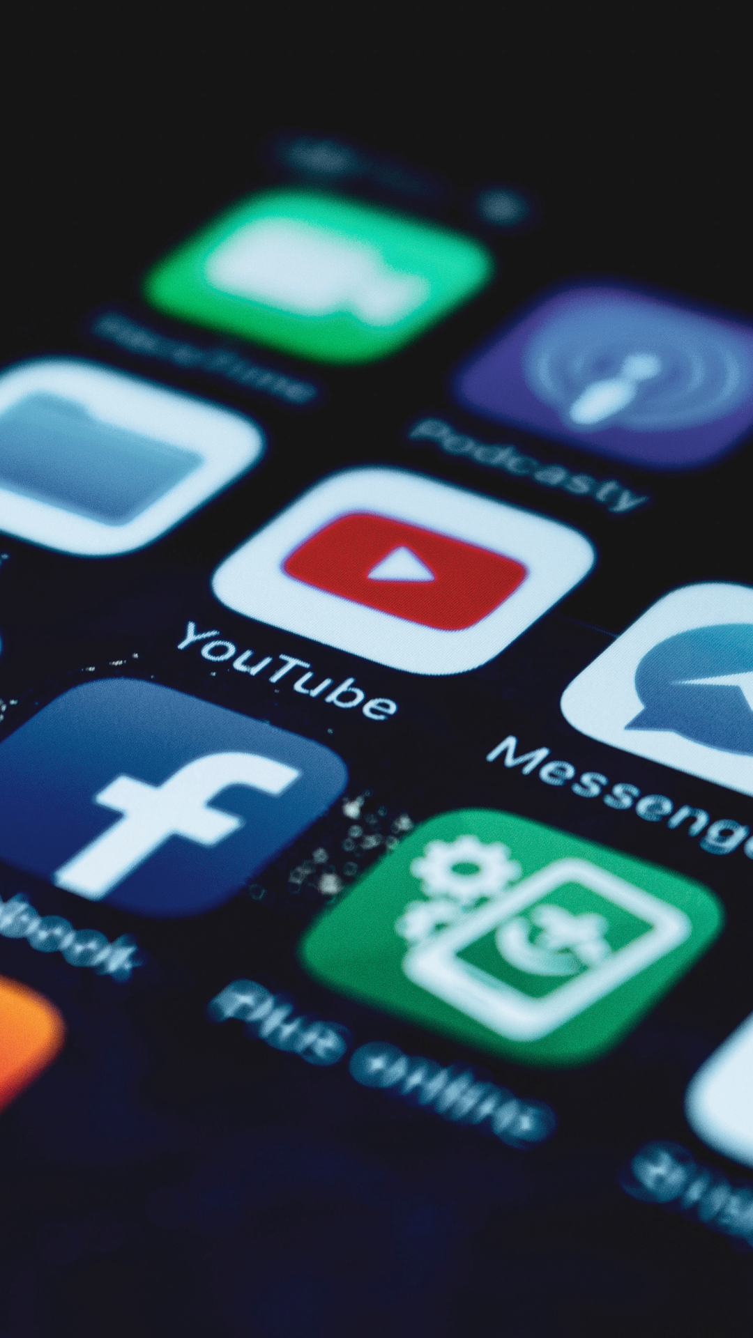 A close up of a cell phone screen with icons for youtube facebook and messenger
