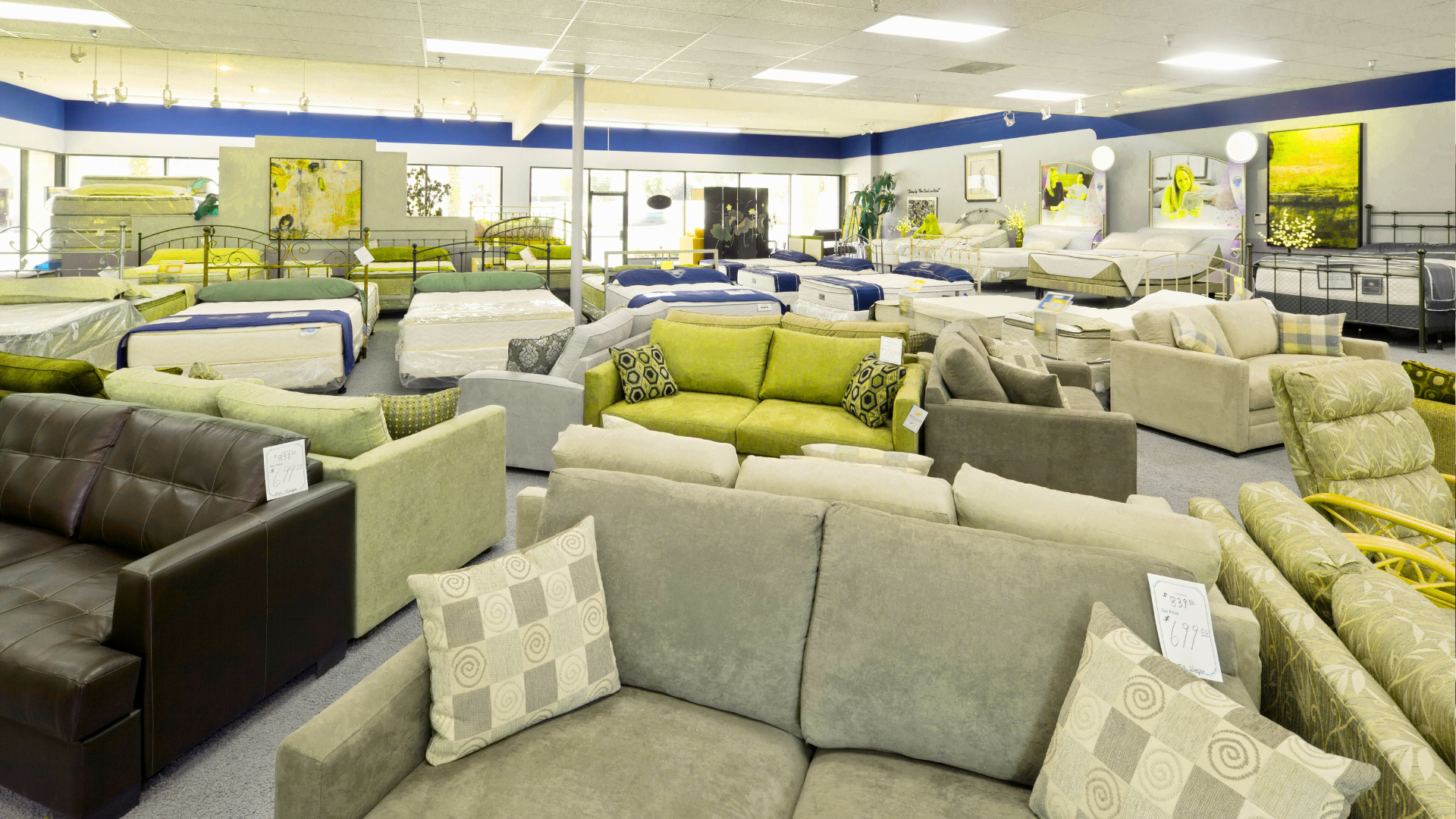 A large room filled with lots of furniture and mattresses.