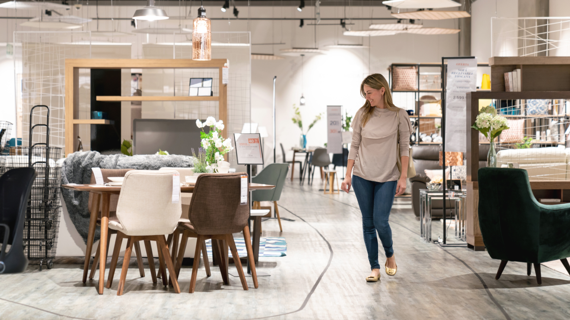A woman is walking through a furniture store.